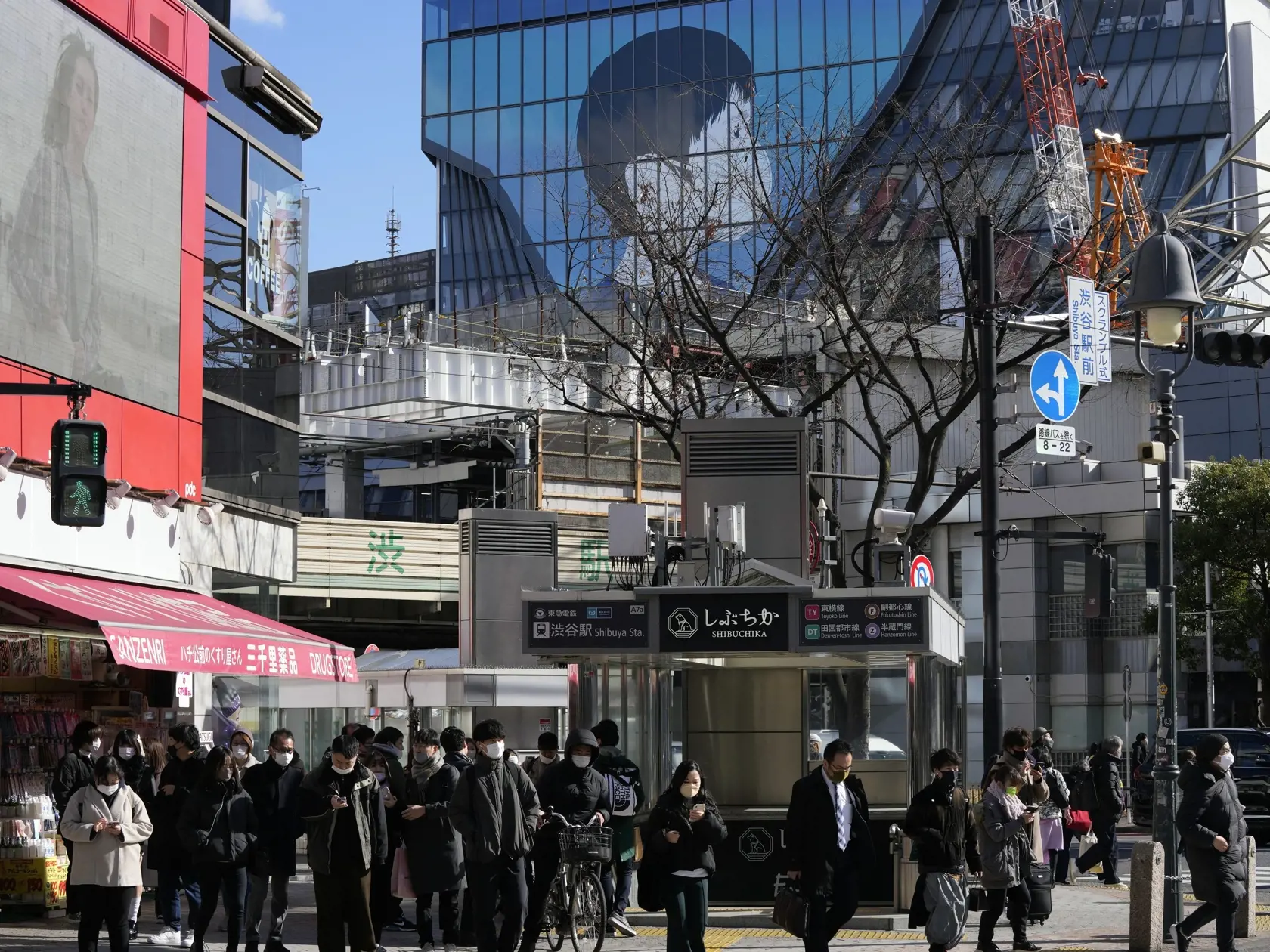 Ľudia s ochrannými rúškami kráčajú cez križovatku v Tokiu 21. januára 2022. Japonská vláda schválila v stredu nové obmedzenia proti koronavírusu pre veľkú časť krajiny vrátane hlavného mesta Tokio. Snaží sa tak bojovať proti rekordnému počtu prípadov nákazy, pripisovanému variantu omikron.
