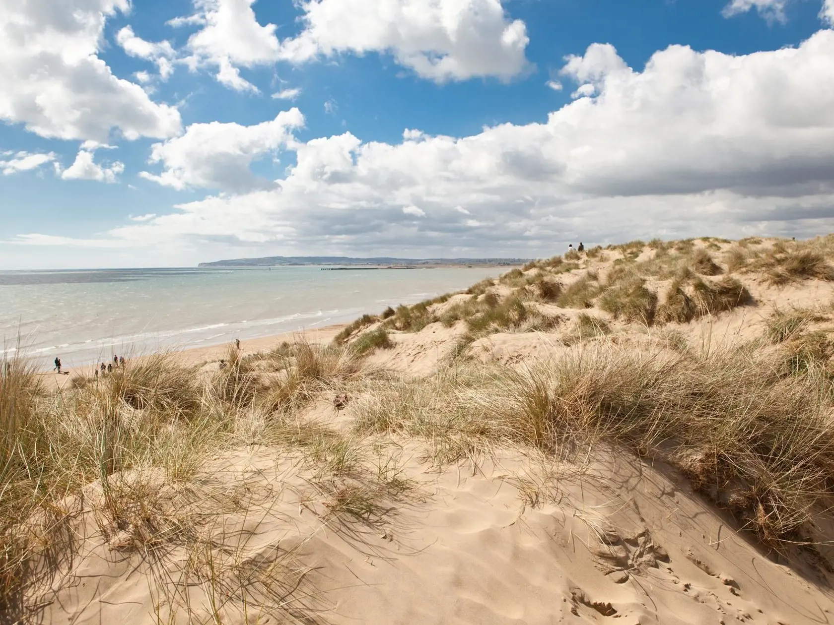 Camber Sands, East Sussex, Anglicko: rýchle prílivové vlny sťahujú do mora aj tých, čo stoja na pláži.