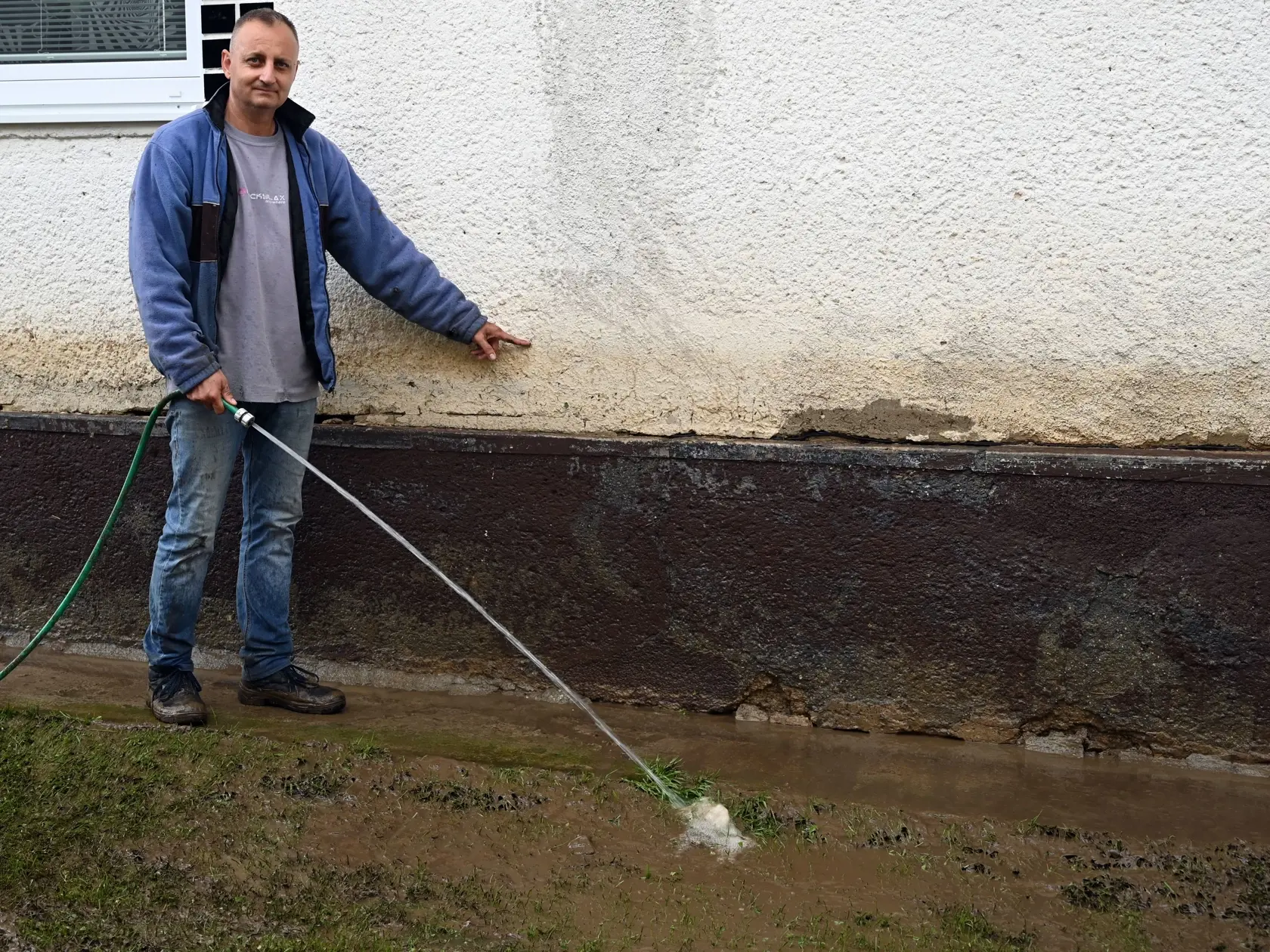 Na snímke obyvateľ ukazuje, pokiaľ až siahala voda po bleskovej povodni v obci Pichne v okrese Snina 19. júna 2020. FOTO TASR - Roman Hanc