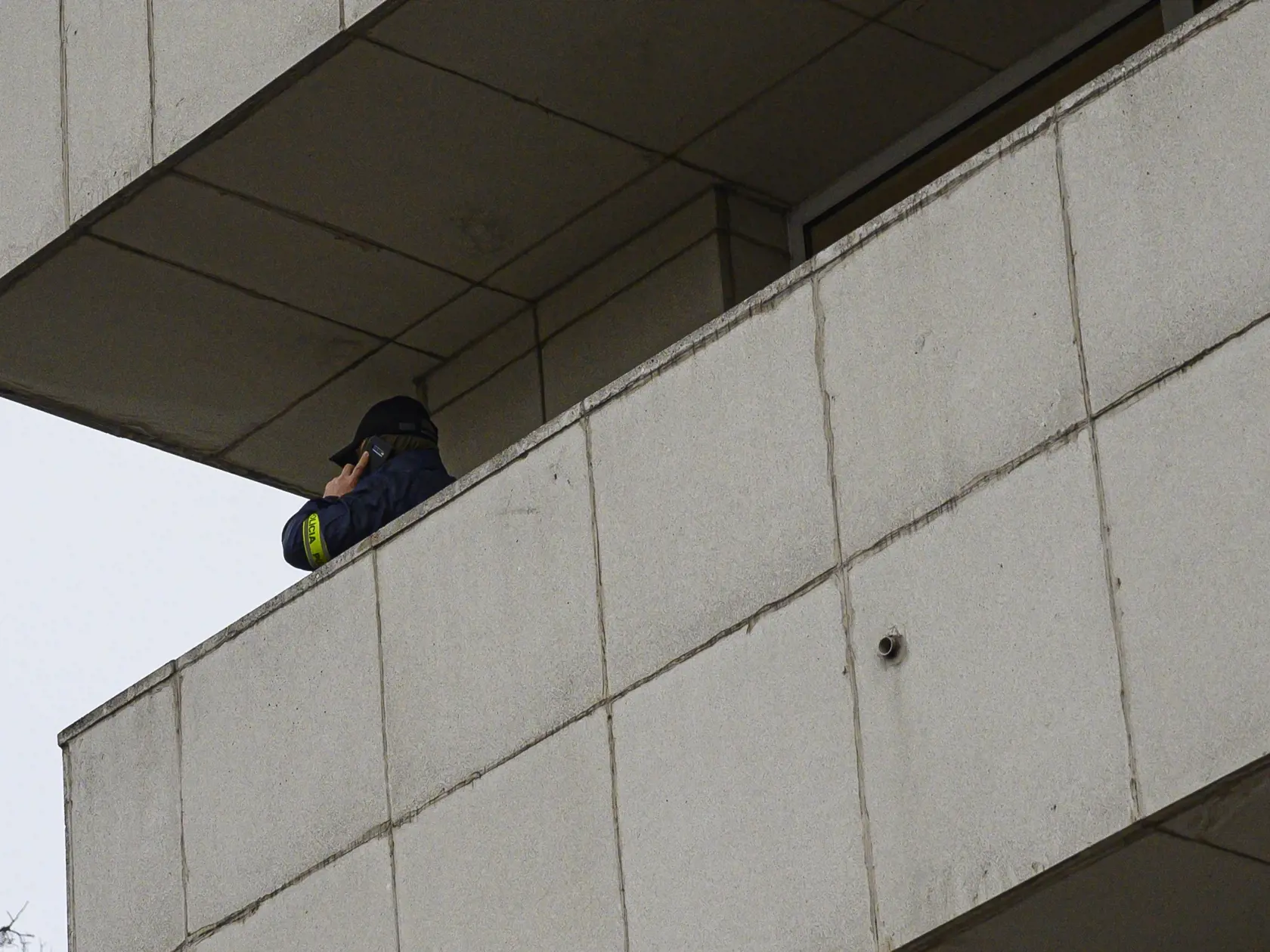 Na snímke príslušník NAKA telefonuje na balkóne budovy štátnej lotériovej spoločnosti Tipos. Bratislava, 26. novembra 2019.  FOTO TASR - Michal Svítok
