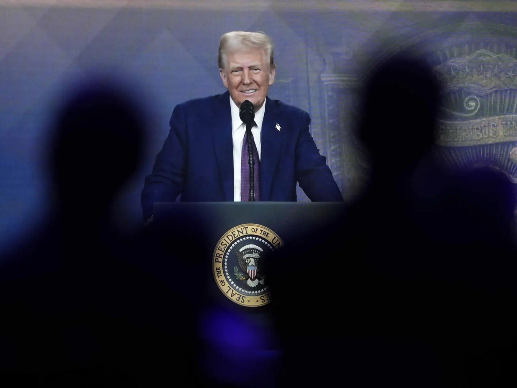 Na archívnej snímke z 23. januára 2025 ľudia sledujú virtuálny prejav prezidenta USA Donalda Trumpa na výročnom zasadnutí Svetového ekonomického fóra vo švajčiarskom Davose.