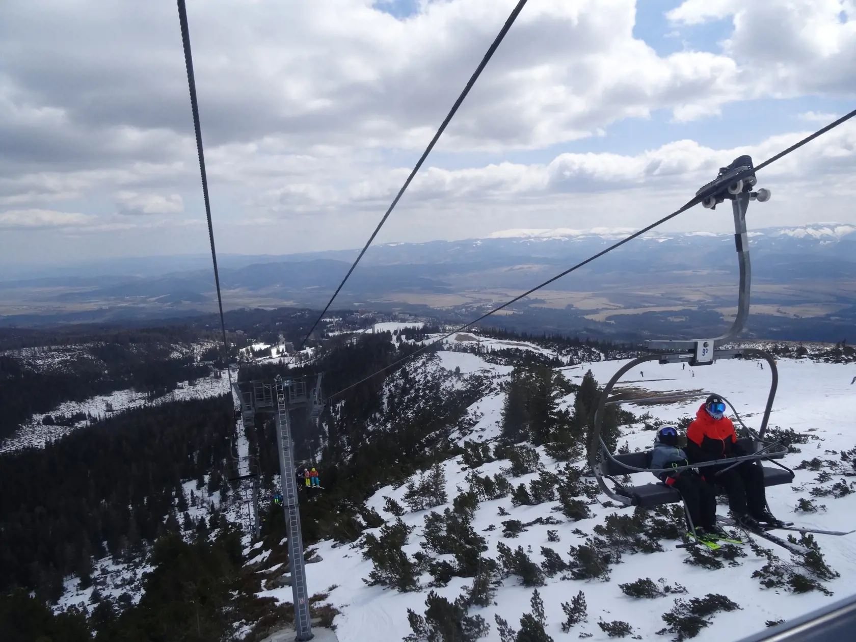 Pohľad z lanovky na slnkom zaliate Tatry.