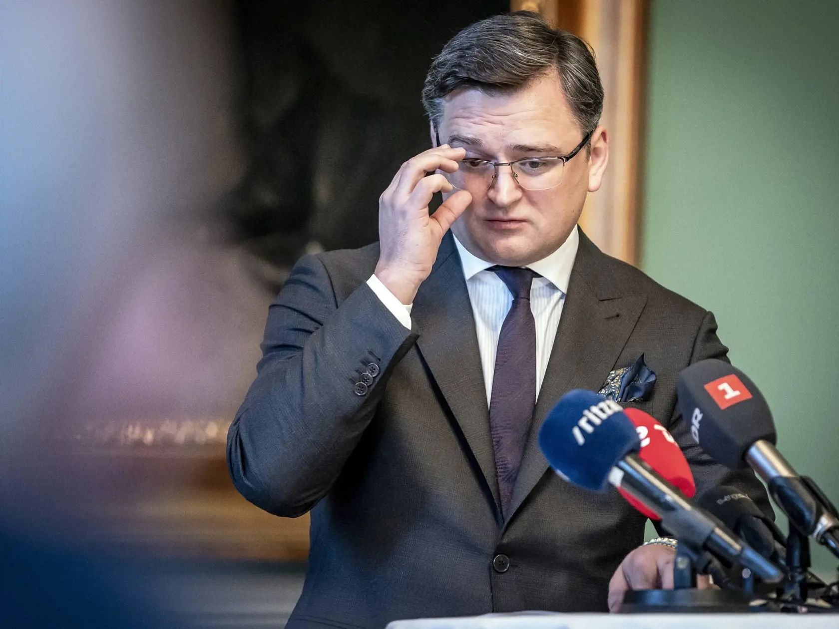 Ukrajinský minister zahraničných vecí Dmytro Kuleba si napráva okuliare počas tlačovej konferencie so svojím dánskym rezortným partnerom Jeppem Kofodom (nie je na snímke) po ich stretnutí v Kodani 27. januára 2022.  Kuleba je na dvojdňovej oficiálnej návšteve Dánska.