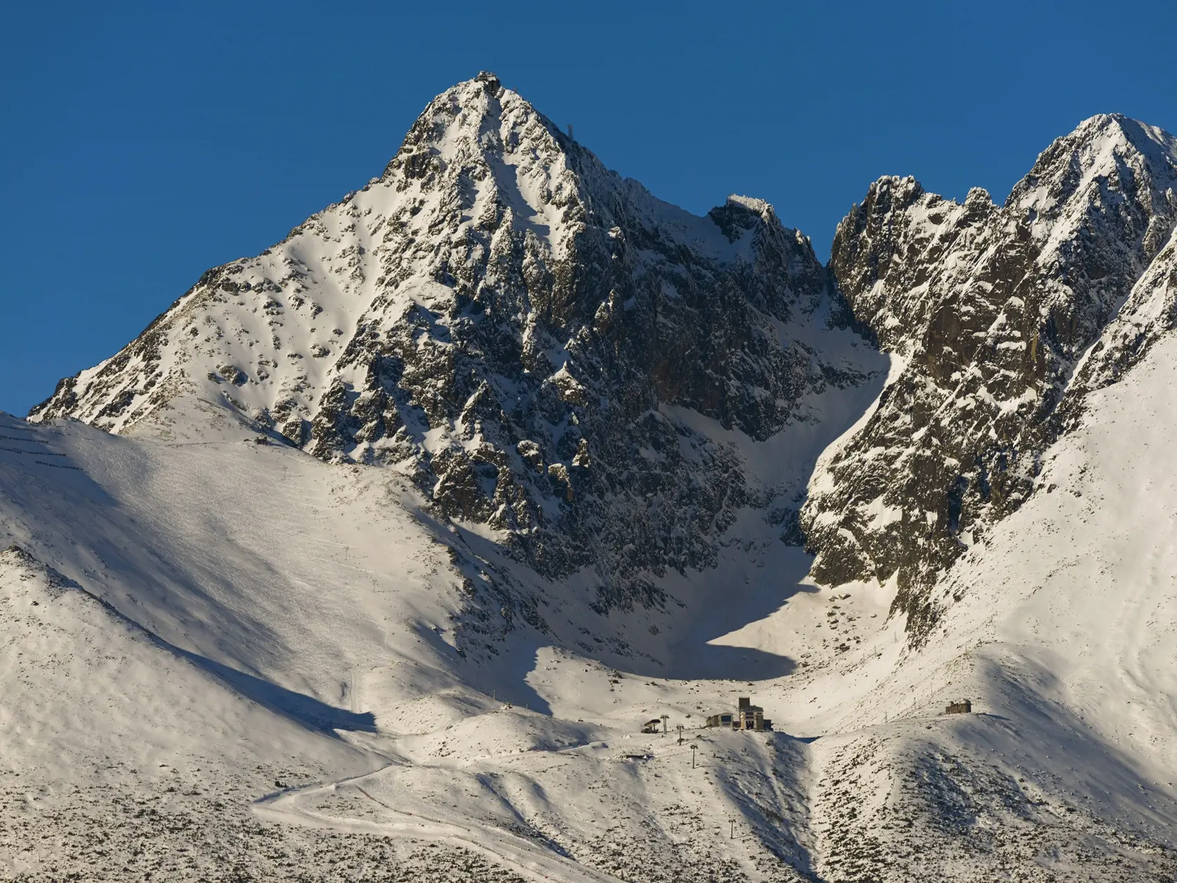 Vysoké Tatry od Veľkej Lomnice. Na snímke vľavo Lomnický a vpravo Kežmarský štít, dole uprostred budova lanovky, vpravo hvezdáreň a vľavo hore Lomnické sedlo s lyžiarskym svahom.