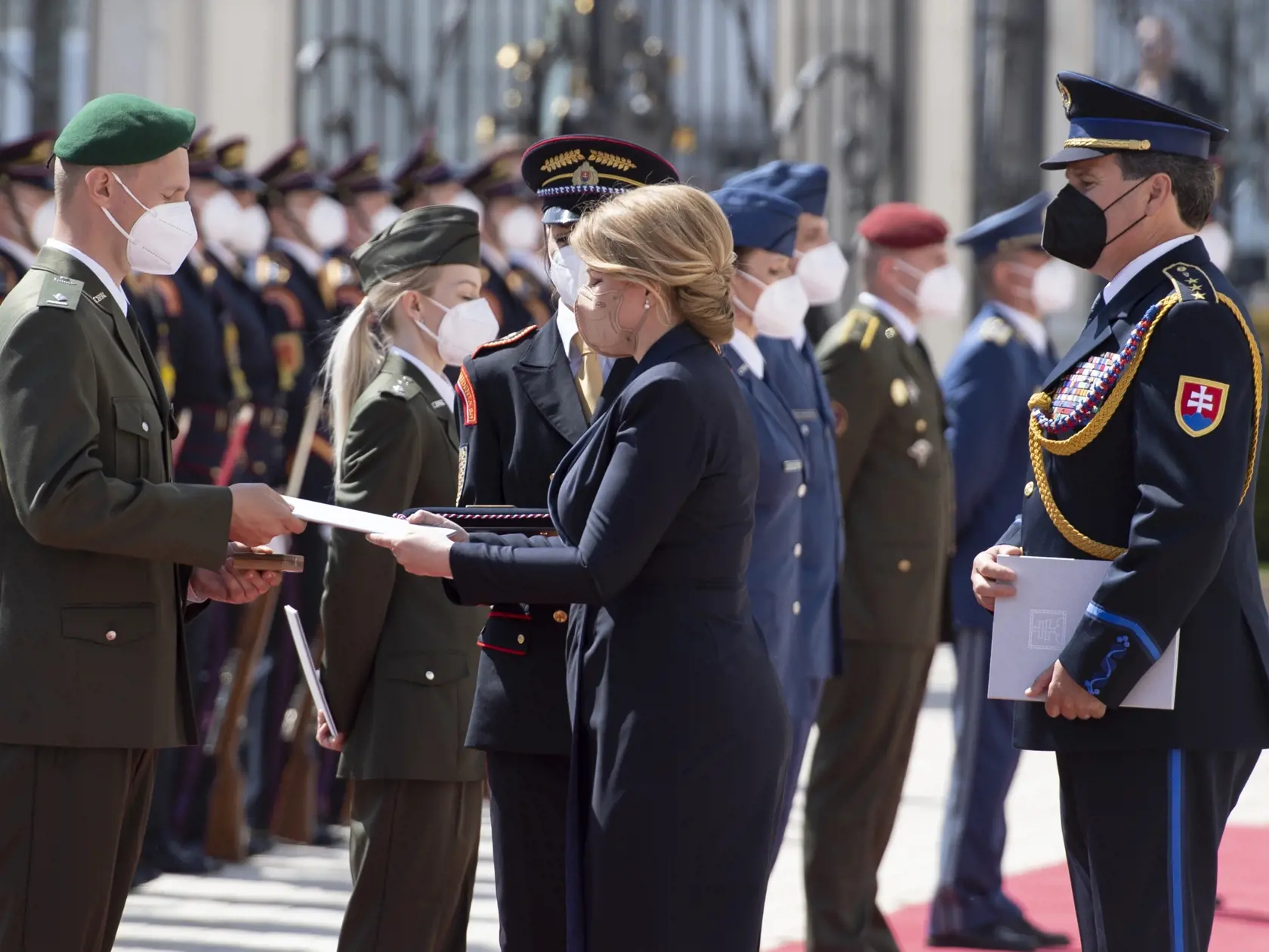 Na snímke vľavo slobodník Juraj Černotov a uprostred prezidentka SR Zuzana Čaputová počas ceremónie udeľovania medailí vojačkám a vojakom, ktorí sa vyznamenali vynaloženým úsilím počas pandémie nového koronavírusu 4. mája 2021 na nádvorí Prezidentského paláca v Bratislave.