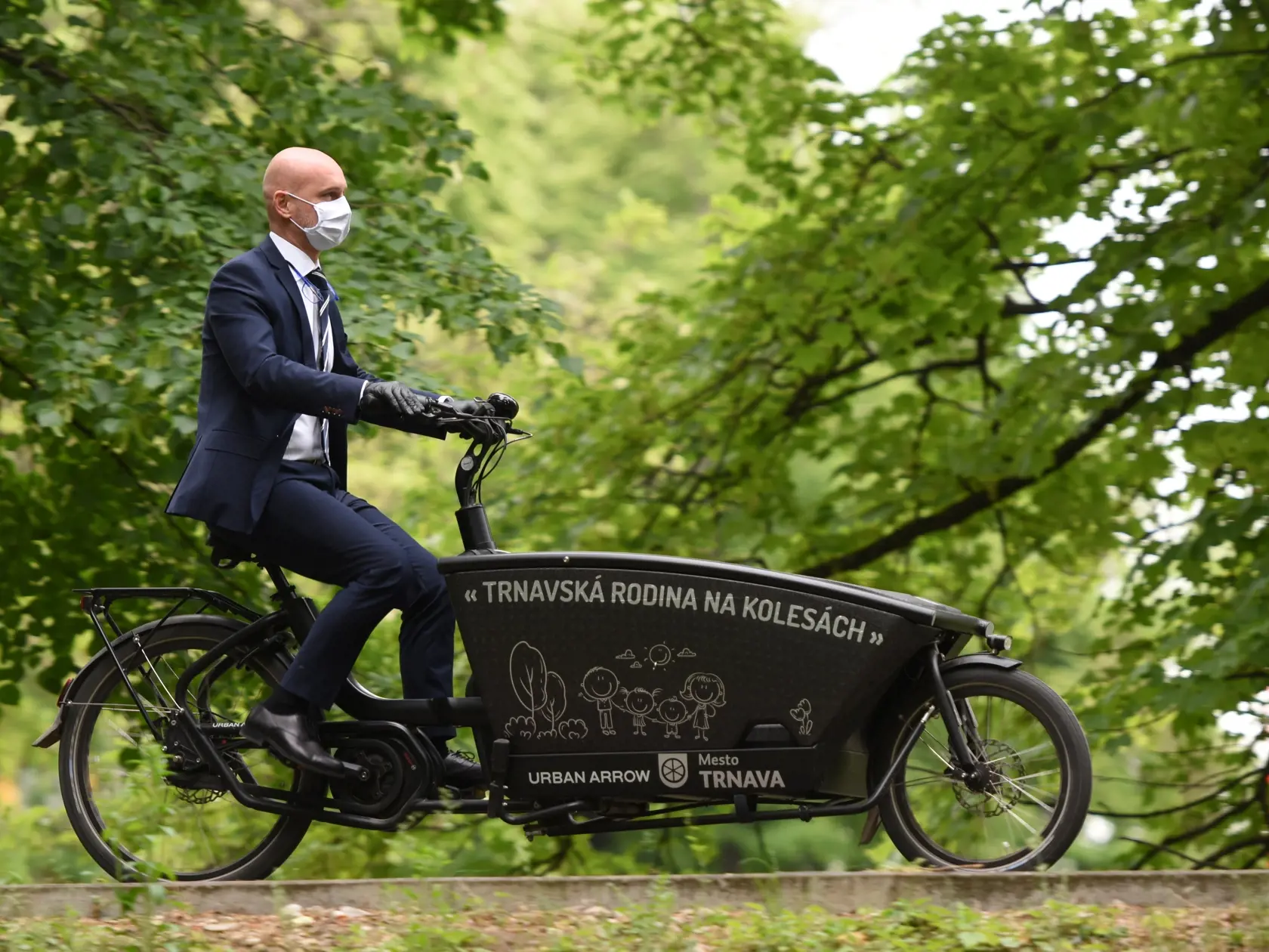Na snímke minister školstva, vedy, výskumu a športu SR Branislav Gröhling (SaS) s ochranným rúškom na tvári a rukavicami počas presunu medzi školami na bicykli v Trnave 13. mája 2020. Minister školstva navštívil tri školy, diskutoval s primátorom Trnavy Petrom Bročkom, predsedom Trnavského samosprávneho kraja (TTSK) Jozefom Viskupičom, vedením škôl a učiteľmi.  FOTO TASR - Lukáš Grinaj