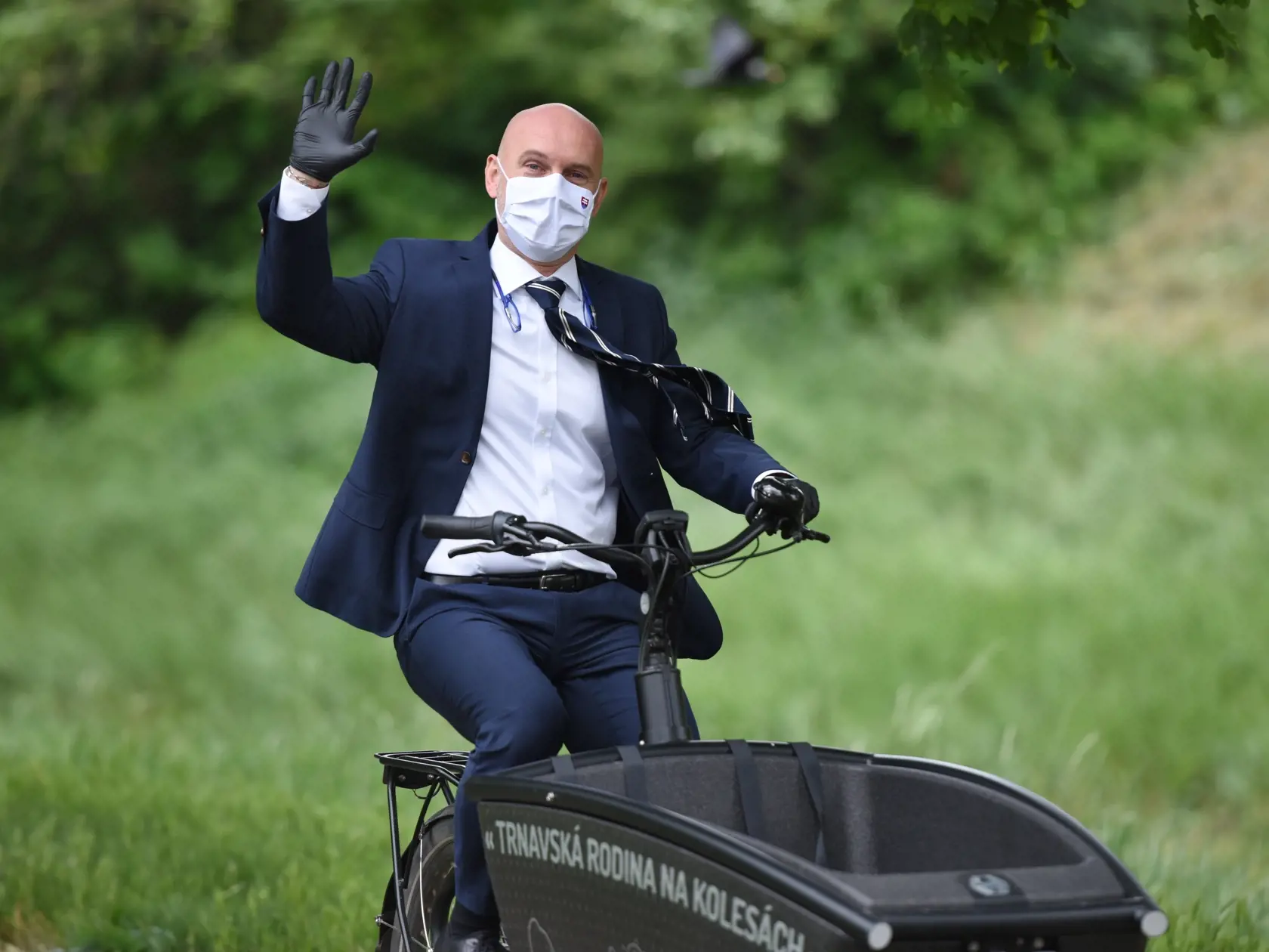 Na snímke minister školstva, vedy, výskumu a športu SR Branislav Gröhling (SaS) s ochranným rúškom na tvári a rukavicami počas presunu medzi školami na bicykli v Trnave 13. mája 2020. Minister školstva navštívil tri školy, diskutoval s primátorom Trnavy Petrom Bročkom, predsedom Trnavského samosprávneho kraja (TTSK) Jozefom Viskupičom, vedením škôl a učiteľmi.  FOTO TASR - Lukáš Grinaj