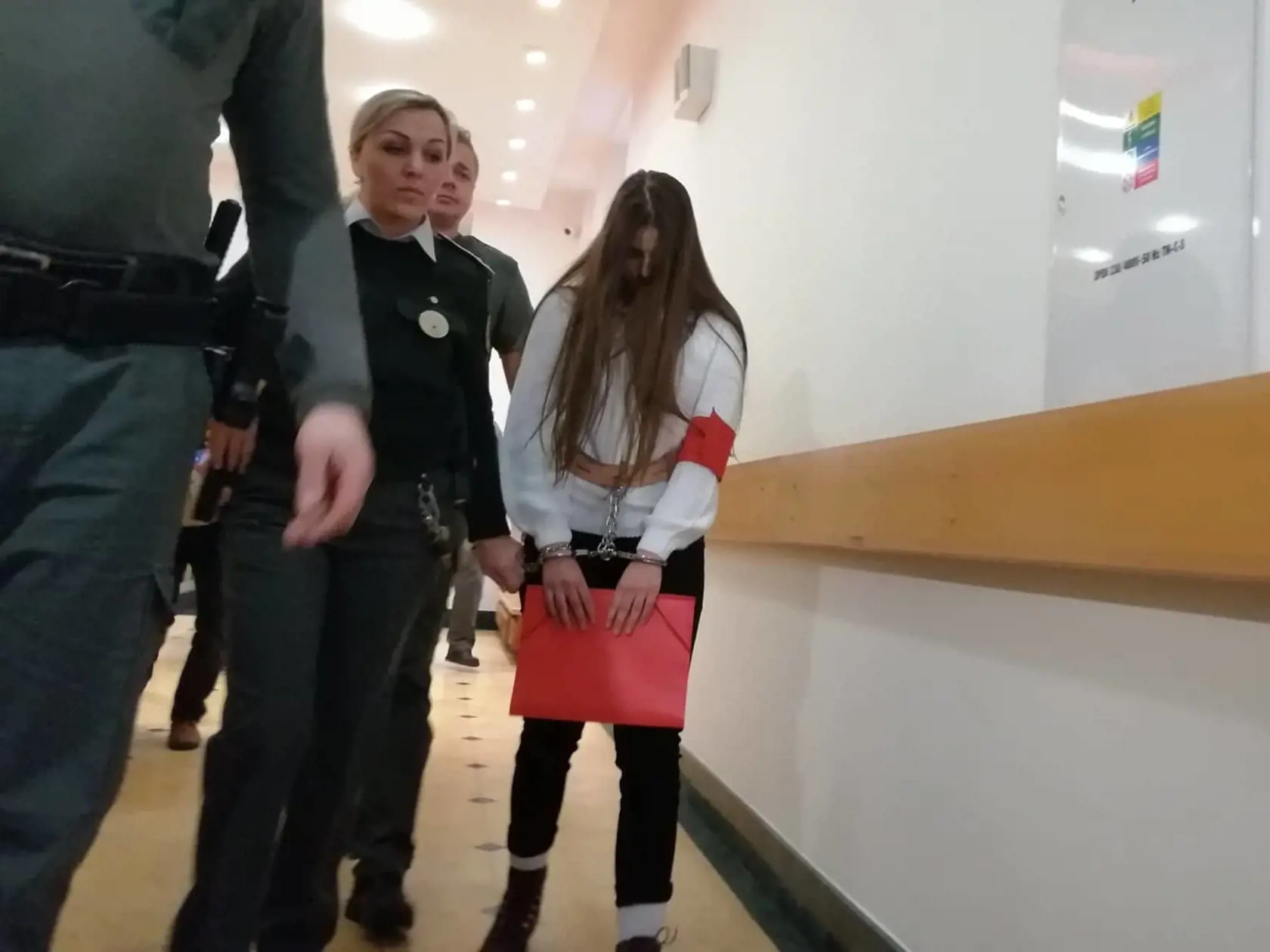 Judita kráčala po chodbe súdu s putami pripevnenými k opasku. Sprevádzala ju dozorkyňa a štyria policajti.