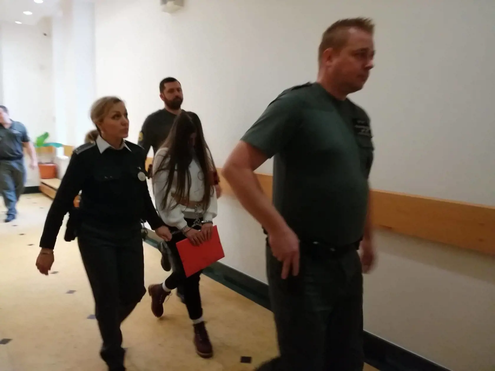 Judita prichádza v putách späť do pojednávacej miestnosti.