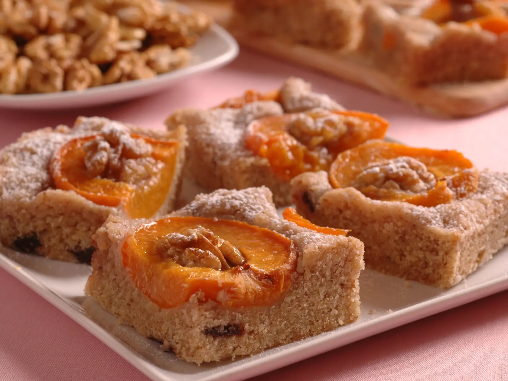 Orechovy kolac s marhulami
8 porcií
Suroviny
120 g masla, 150 g hladkej múky, 80 g pomletých orechov, 100 g práškového cukru, 2 lyžice ovocnej šťavy, 2 vajcia, 40 g tmavej čokolády, 500 g marhúľ, 2 čl kypriaceho prášku do pečiva, vlašské  orechy, 1 lyžica cukru, 2 lyžice rozpusteného masla

Pracovný postup
Zmäknuté maslo vymiešame s práškovým cukrom, a so žĺtkami. Pridáme hladkú múku, nastrúhanú čokoládu, kypriaci prášok,  pomleté orechy, ovocnú šťavu, a z bielkov ušľahaný tuhý sneh z bielkov. C