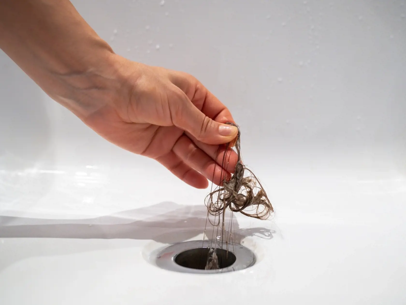 Hand,Pulls,Hair,Out,Of,Bathroom,Drain.,Female,Palm,Extracts