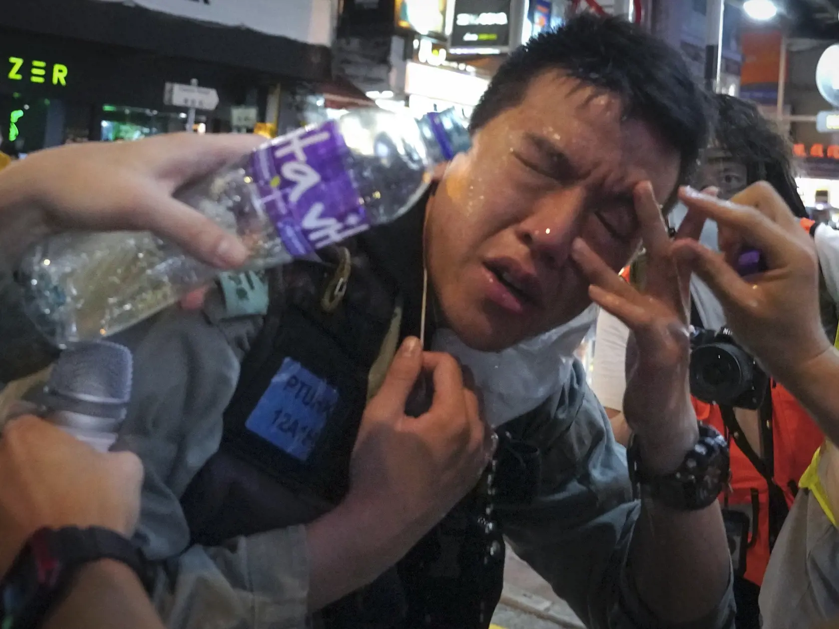 JB 11 Hongkong - Príslušník hongkongských poriadkových síl si vyplachuje oči s pomocou ďalších policajtov po tom, ako bol zasiahnutý paprikovým sprejom počas protestu demonštrantov na Causeway Bay v Hongkongu 12. júna 2020. Protesty zvolané pri príležitosti pripomenutia si prvého výročia od začiatku prodemokratických demonštrácií zároveň prichádzajú v čase stúpajúceho napätia v súvislosti s pripravovaným zákonom o národnej bezpečnosti, ktorý minulý týždeň schválil čínsky parlament. FOTO TASR/AP 