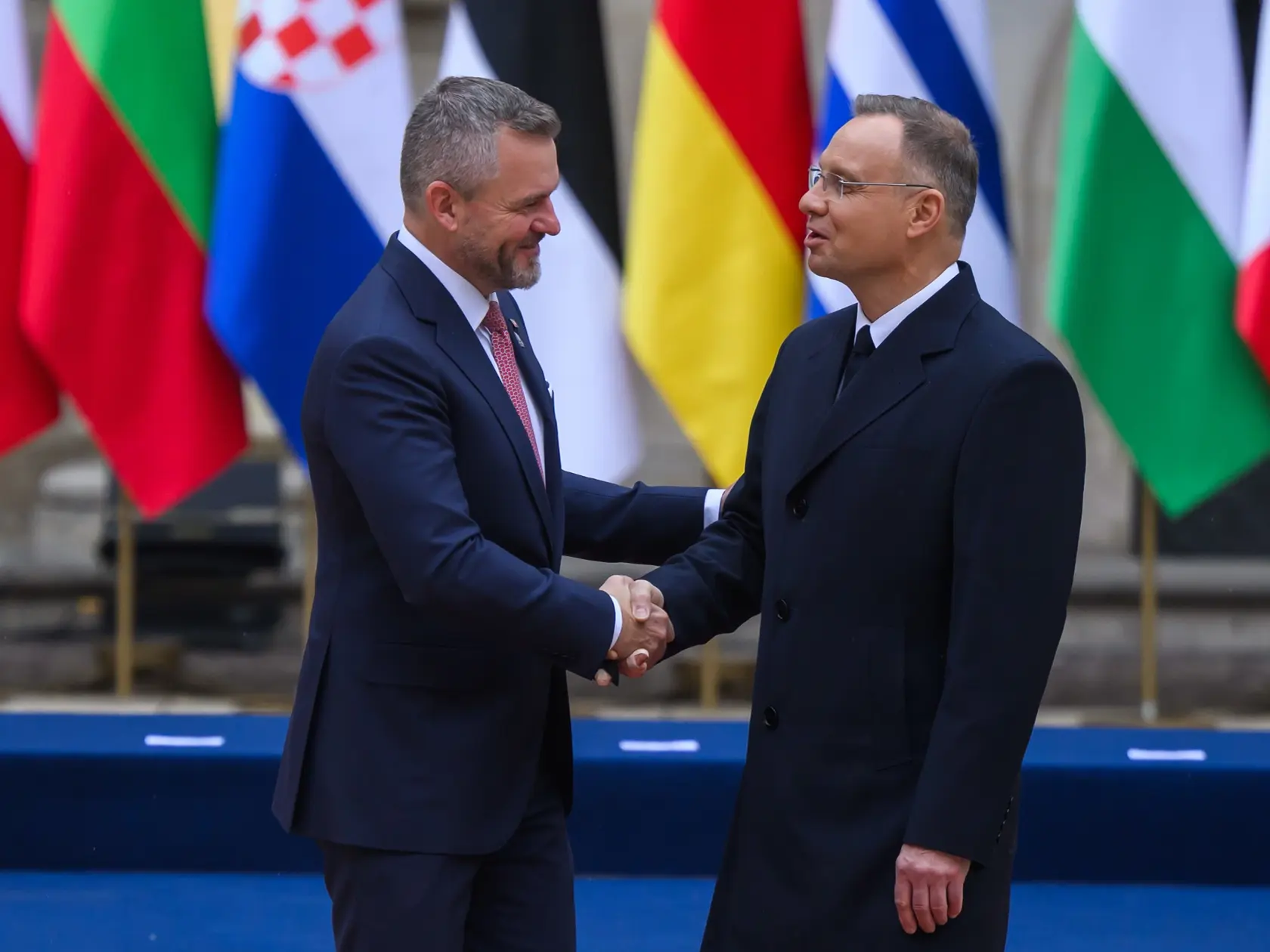 Na snímke zľava prezident SR Peter Pellegrini a poľský prezident Andrzej Duda si podávajú ruky počas stretnutia hláv štátov v rámci skupiny Arraiolos.
