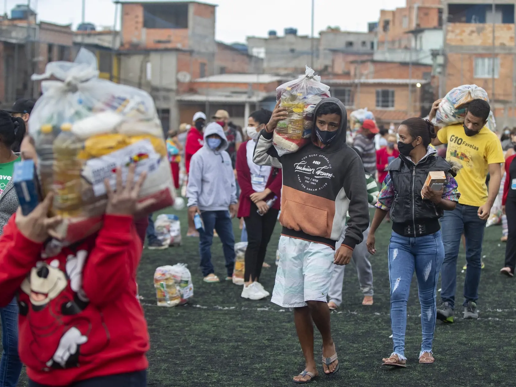 WA 32 Sao Paulo - Miestni obyvatelia si odnášajú z futbalového ihriska balík s potravinami, ktoré im zabezpečila nezisková organizácia počas koronavírusovej pandémie v Sao Paule v pondelok 26. apríla 2021. FOTO TASR/AP 

Residents wait on a soccer field for food donated by the local NGO "G10 Favelas," amid the COVID-19 pandemic in the Capao Redondo area of Sao Paulo, Brazil, Monday, April 26, 2021. (AP Photo/Andre Penner)
