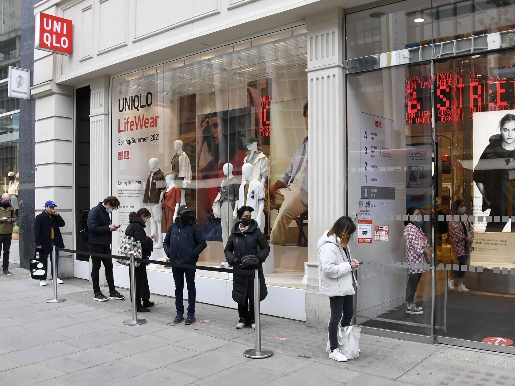 EBE 32 Londýn - Na snímke ľudia stoja v rade pred vchodom do obchodu na Oxford Street v Londýne v pondelok 12. apríla 2021. V Anglicku a Írsku sa uvoľňujú niektoré protipandemické opatrenia a tak ľudia dostanú prvú šancu navštíviť kaderníctva, neformálne nakupovať a stravovať sa v reštauráciách. FOTO TASR/AP
People queue waiting their turn to enter a shop in Oxford street in London, Monday, April 12, 2021. Millions of people in England will get their first chance in months for haircuts, casual s