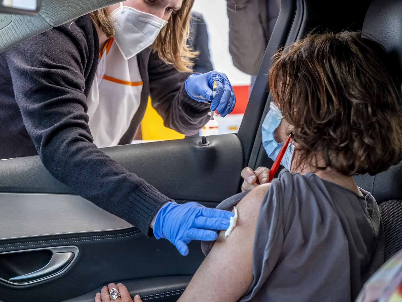 EBE 25 Pforzheim - Na snímke žena podstupuje očkovanie vakcínou AstraZeneca v automobile na parkovisku supermarketu v Pforzheimu v južnom Nemecku v stredu 5. mája 2021.Autá s ľuďmi čakajúcimi v rade na očkovanie proti ochoreniu COVID-19 vakcínou AstraZeneca na parkovisku supermarketu v nemeckom Pforzheime 5. mája 2021. Lekár, ktorý sa nemohol zbaviť svojej vakcíny AstraZeneca v ordinácii, sa rozhodol, že ponúknite asi 250 dávok vo vakcinačnom mieste v supermarkete. FOTO TASR/AP

A woman sits in 