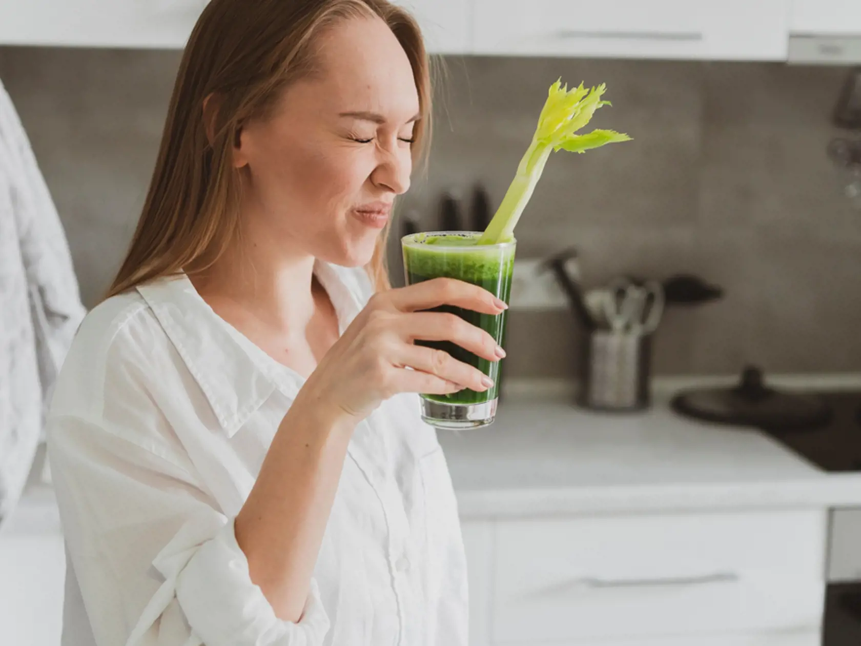 Young,Woman,Drinking,Healthy,Spinach,And,Celery,Smoothie,At,Home