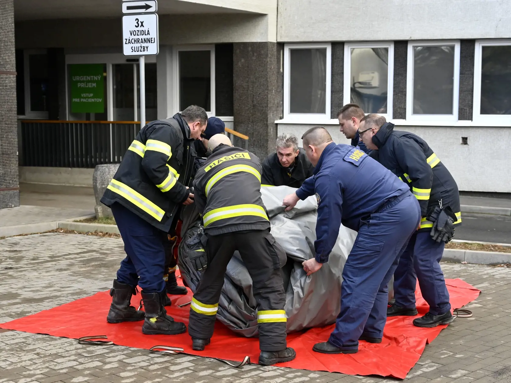 Triážne stany pred nemocnicami, ktoré počas štvrtej vlny pandémie poslúžia ako triediace pracoviská pre pacientov pred urgentnými príjmami, postavia príslušníci Hasičského a záchranného zboru (HaZZ). Na snímke hasiči stavajú triediaci stan pred urgentným príjmom Nemocnice Svet zdravia a.s. v Trebišove 3. februára 2022. FOTO TASR - Roman Hanc