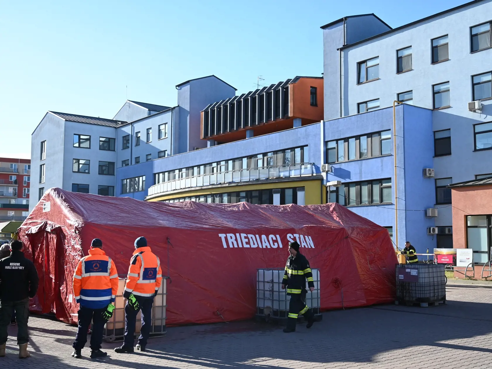Triážne stany pred nemocnicami, ktoré počas štvrtej vlny pandémie poslúžia ako triediace pracoviská pre pacientov pred urgentnými príjmami, postavia príslušníci Hasičského a záchranného zboru (HaZZ). Na snímke hasiči stavajú triediaci stan pred Fakultnou nemocnicou v Trnave vo štvrtok 3. februára 2022. FOTO TASR - Lukáš Grinaj
