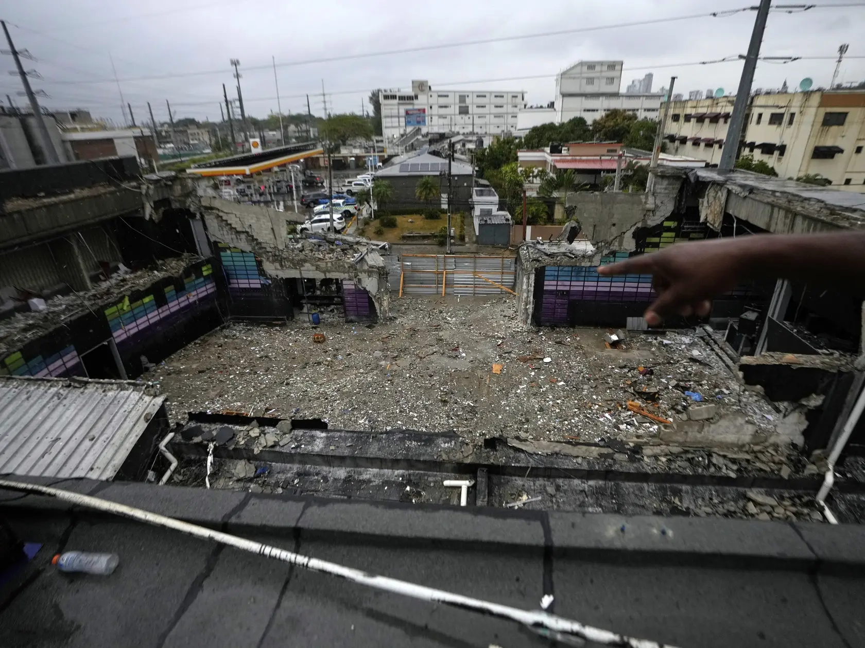 JB 33 Santo Domingo - Pohľad na miesto utorkového zrútenia strechy v nočnom klube v meste Santo Domingo 11. apríla 2025. Na 218 mŕtvych stúpol počet obetí utorkového zrútenia strechy v nočnom klube Jet Set v hlavnom meste Dominikánskej republiky. Oznámil to vo štvrtok šéf zasahujúcich záchranárov Juan Manuel Méndez. TASR o tom informuje na základe správy agentúry AFP. FOTO TASR/AP

A person points to the inside of the Jet Set nightclub days after its roof collapsed, killing more than 200 people, in Santo Domingo, Dominican Republic, Friday, April 11, 2025. (AP Photo/Matias Delacroix)