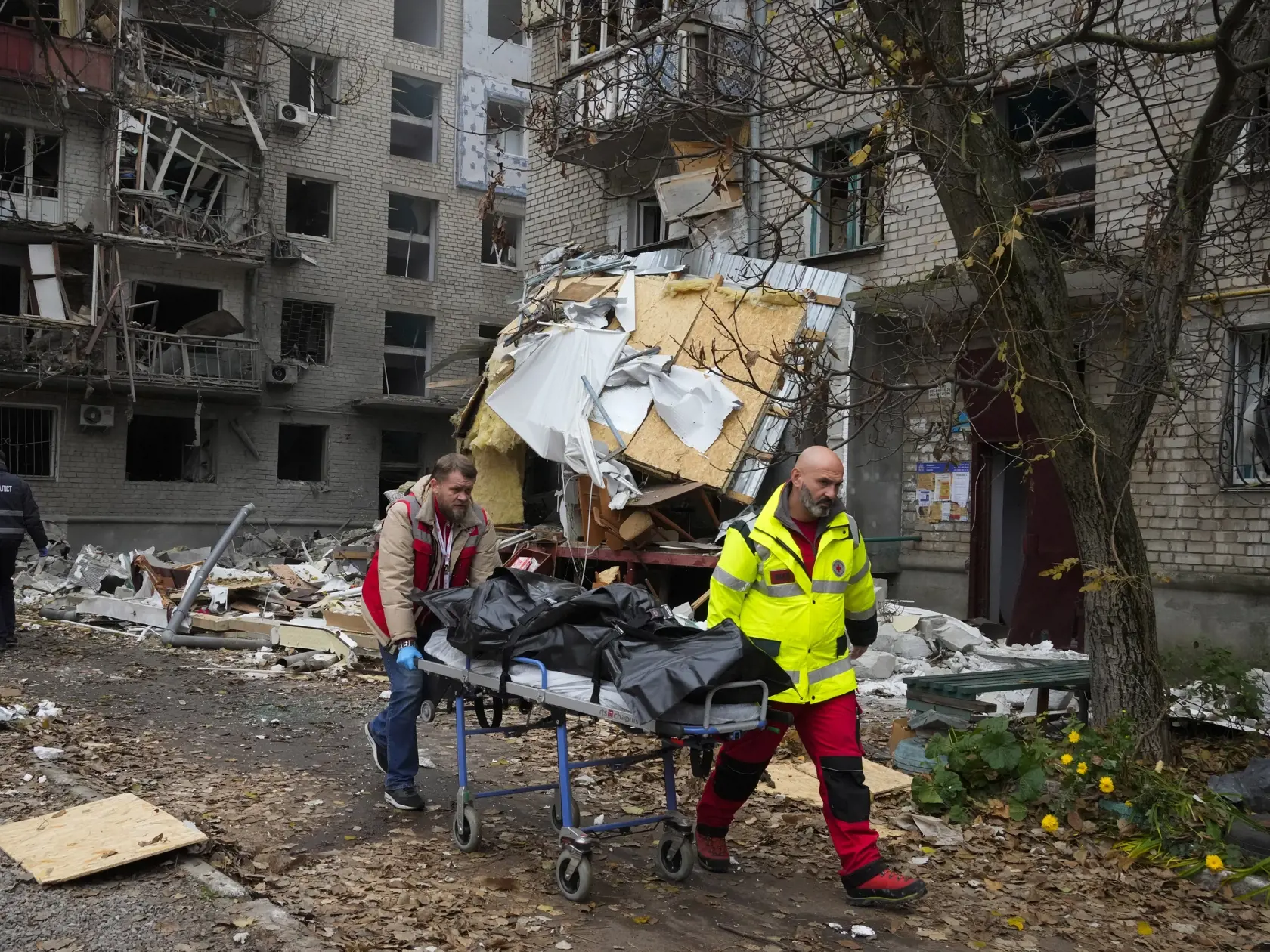 Záchranári odnášajú telo obete, ktoré našli v troskách zničenej bytovky po nočnom ruskom raketovom útoku v juhoukrajinskom meste Mykolajiv v piatok 11. novembra 2022.