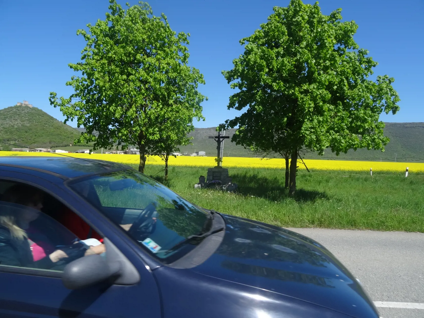 Pri ceste stojí aj veľký kríž na kamennom podstavci.