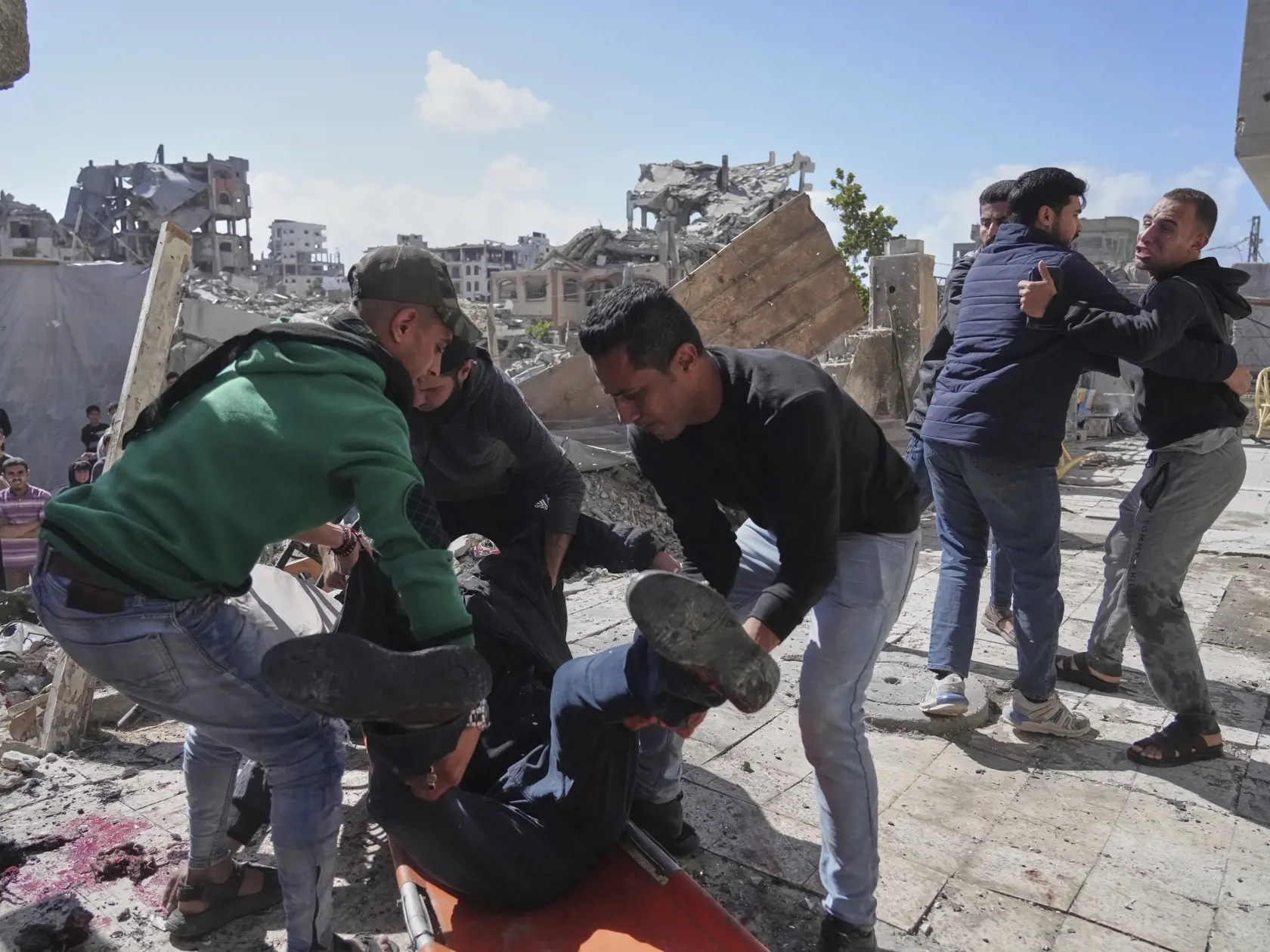 Palestínčania evakuujú zraneného muža po tom, ako jeho dom zasiahlo izraelské bombardovanie v Gaze v stredu 19. marca 2025.
