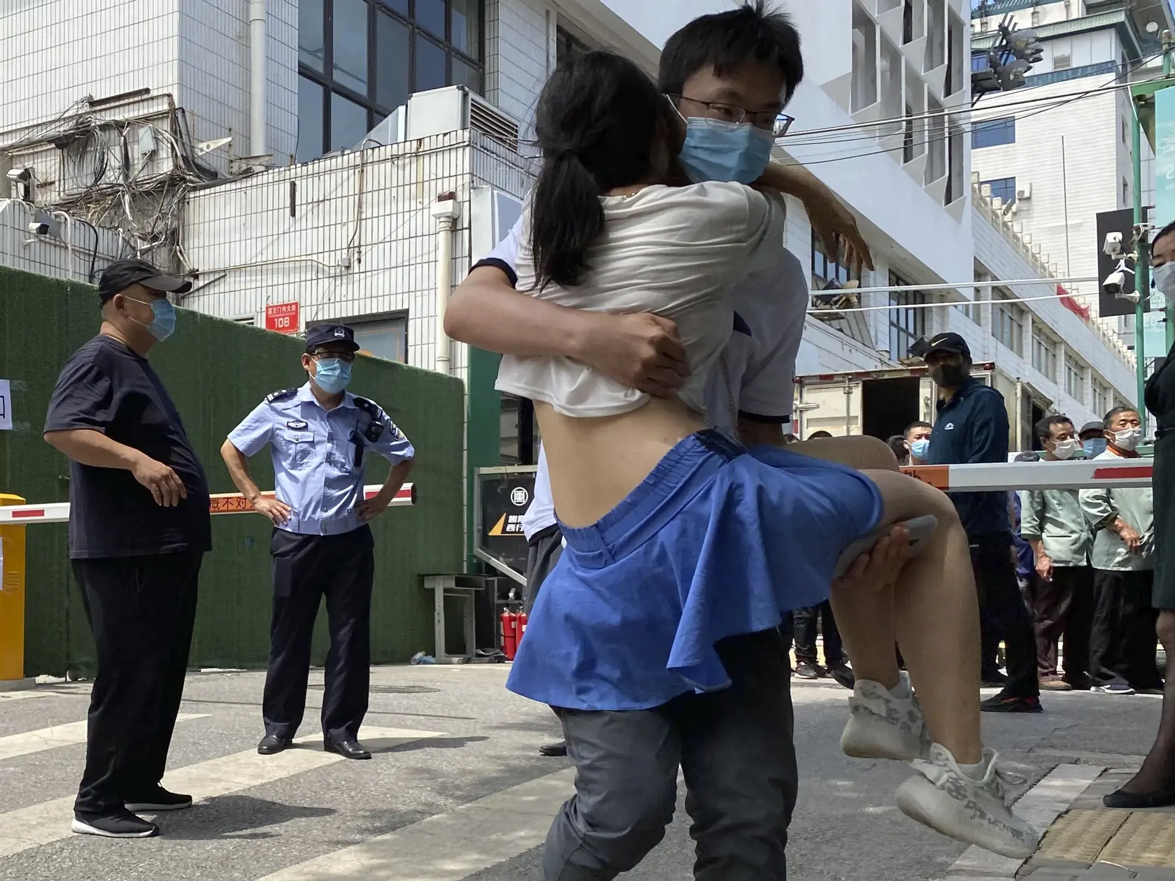 WA 9 Peking - Ženu odnášajú na rukách po testovaní na nový druh koronavírusu v Pekingu v utorok 16. júna 2020. Situácia v čínskej metropole Peking je "mimoriadne vážna", oznámil v utorok hovorca mestskej administratívy Sü Che-ťien v súvislosti s novými prípadmi nákazy novým koronavírusom. Úrady už spustili hromadné testovanie obyvateľstva a v takmer 30 štvrtiach Pekingu zaviedli karanténu. Novým ohniskom nákazy je veľké farmárske trhovisko Sin-fa-ti, čo vyvolalo obavy možnej druhej vlny epidémie