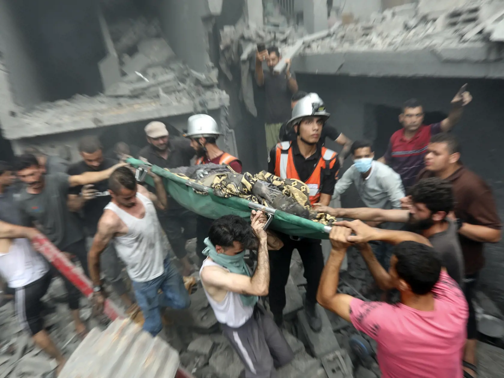 Palestínčania vynášajú telo obete, ktorú našli medzi troskami po raketovom útoku izraelskej armády v pásme Gazy v piatok 27. októbra 2023.
