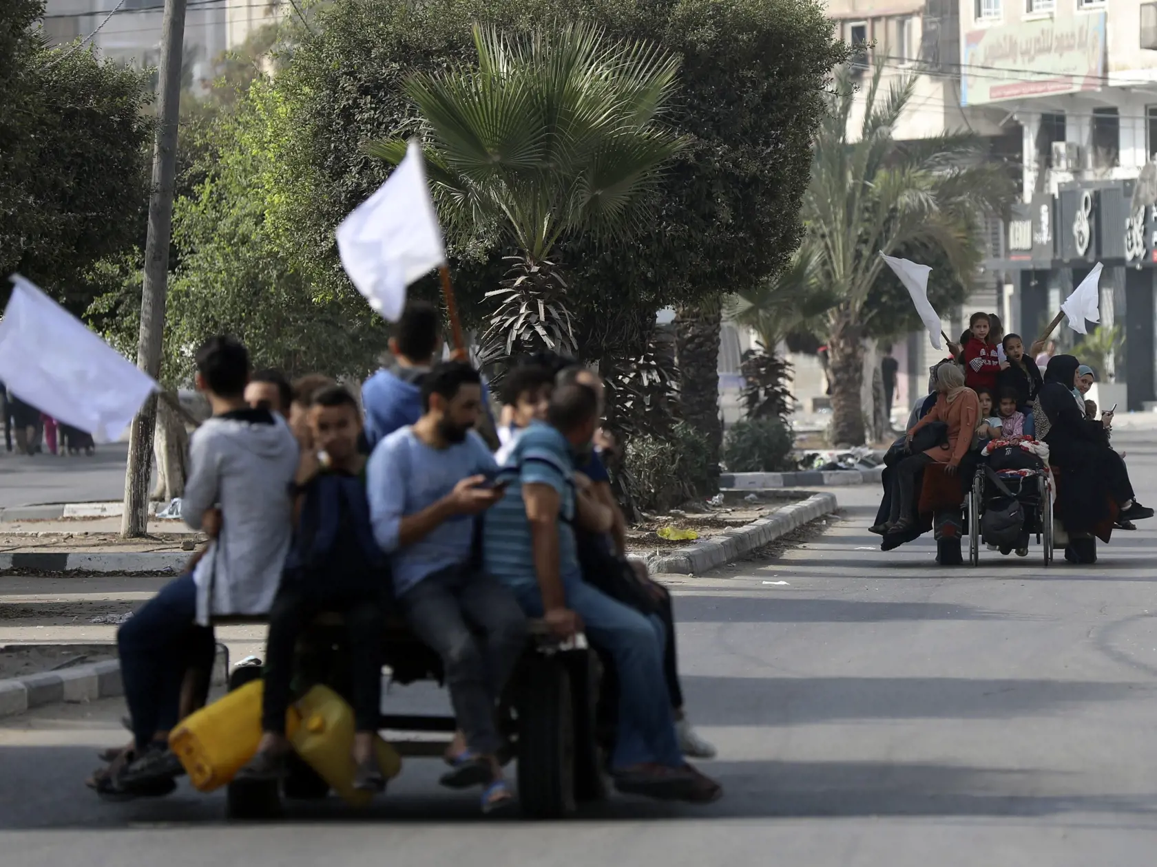 Palestínčania na somárskych povozoch s bielymi zástavami v štvrti centrálnej Gazy al-Rimal utekajú na juh pásma Gazy 8. novembra 2023.