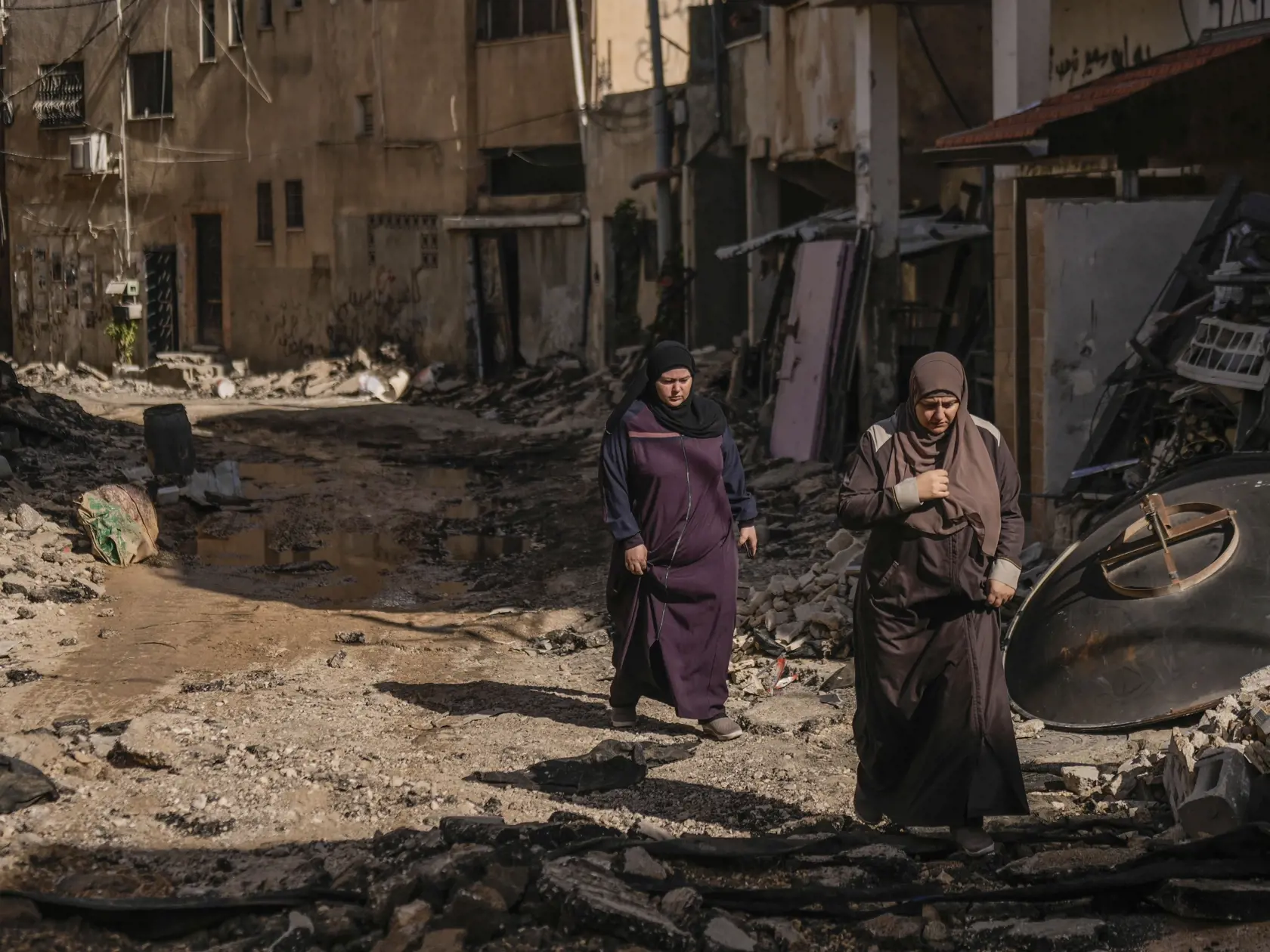 Palestínčanky kráčajú na ulici v oblasti zničenej po izraelskom vojenskom útoku v utečeneckom tábore Džanín, na Západnom brehu Jordánu 10. novembra 2023.