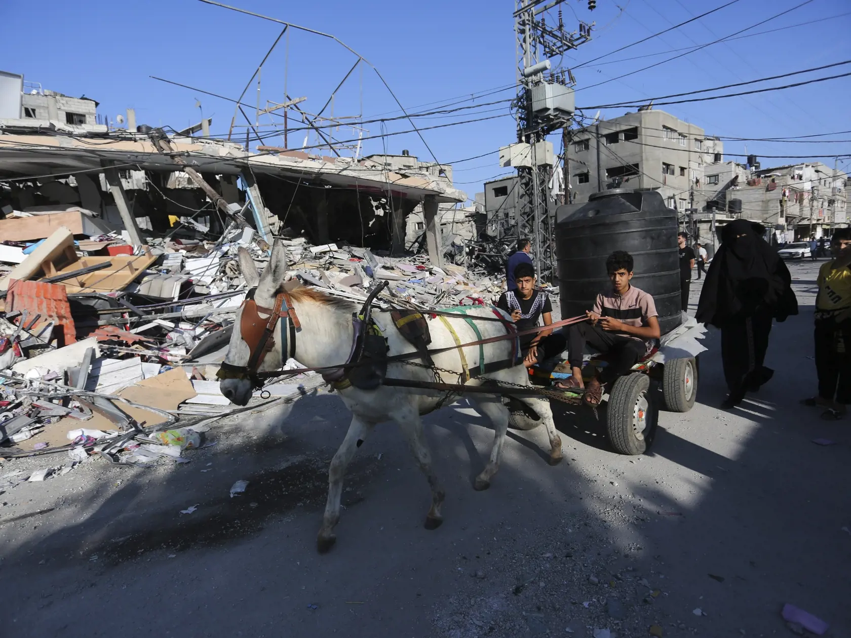 Palestínčania prechádzajú okolo trosiek zničenej budovy po izraelskom leteckom útoku na pásmo Gazy v Rafahu 31. októbra 2023.