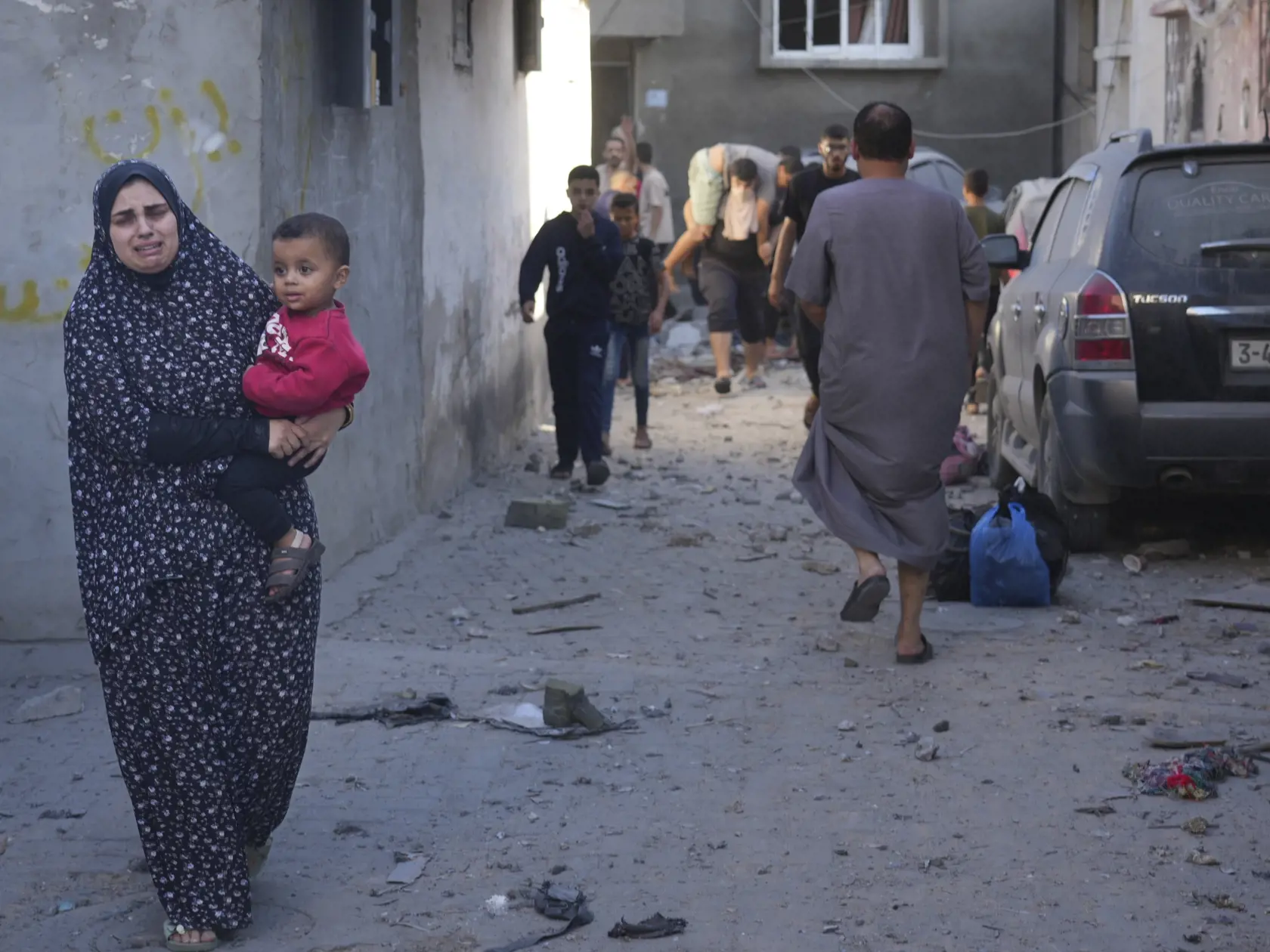 Palestínčanka nesie svoje dieťa po izraelskom leteckom útoku na pásmo Gazy v utečeneckom tábore Nusseirat 4. novembra 2023.
