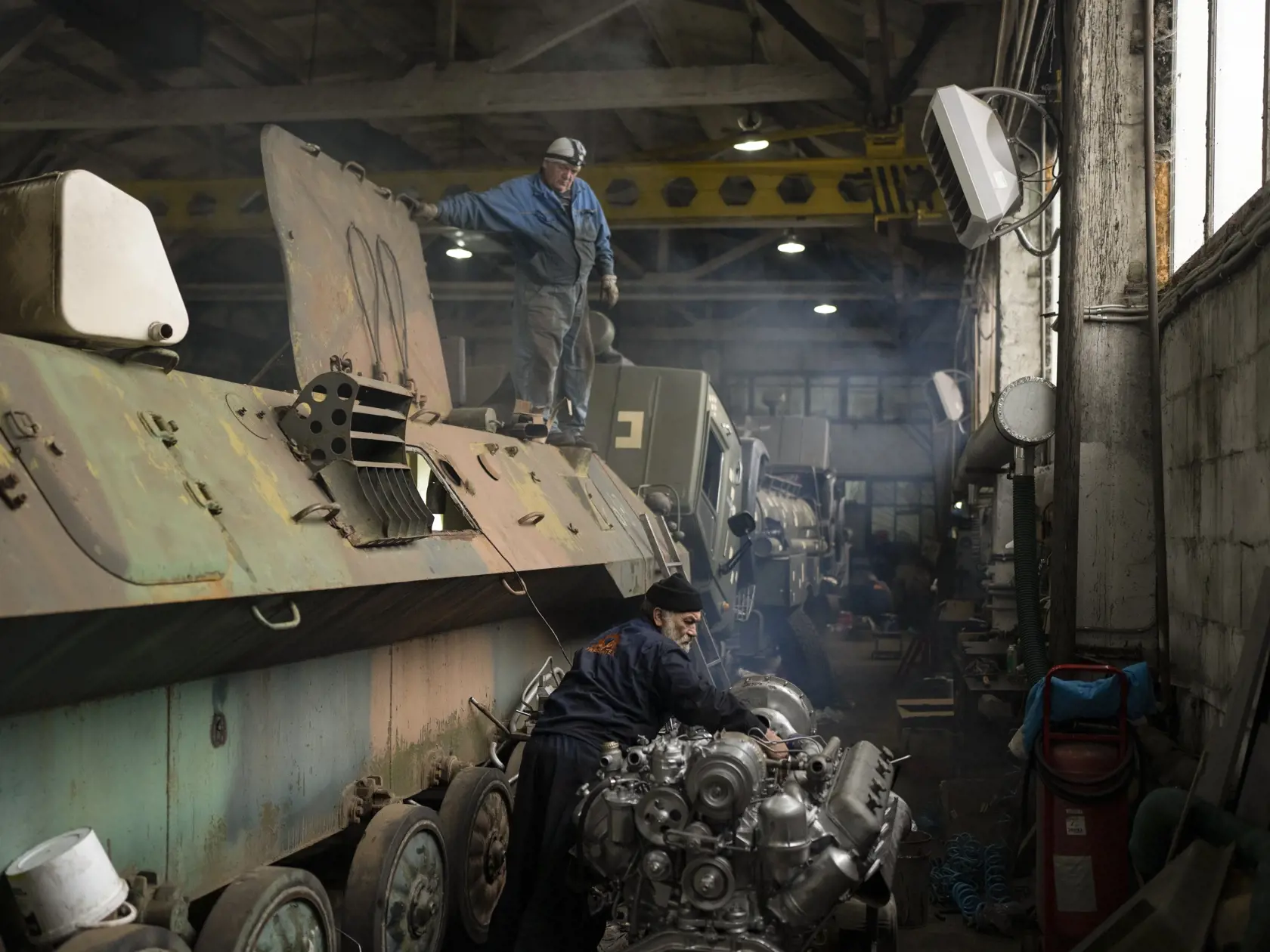 Mechanici opravujú ukrajinské vojenské vozidlá v opravovni tankov v Kyjevskej oblasti 20. októbra 2023.