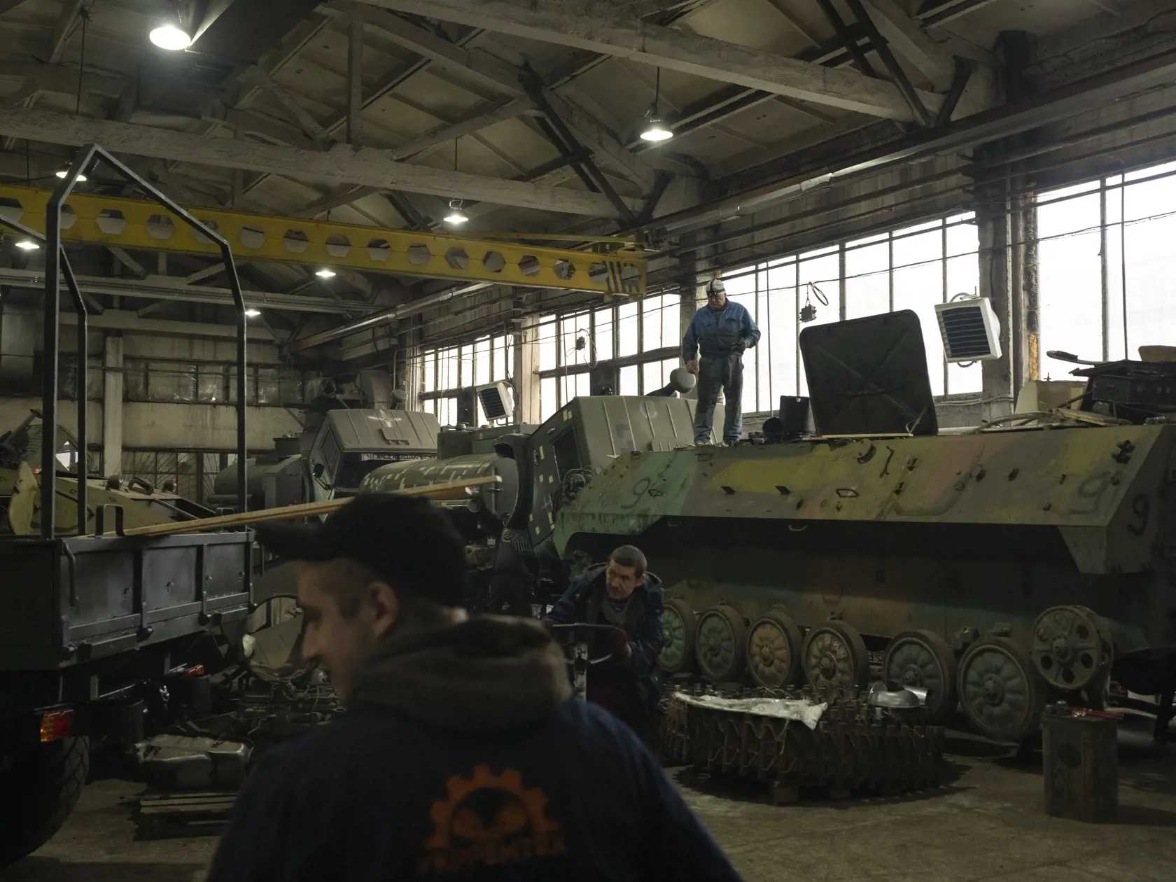 Mechanici opravujú ukrajinské vojenské vozidlá v opravovni tankov v Kyjevskej oblasti 20. októbra 2023.