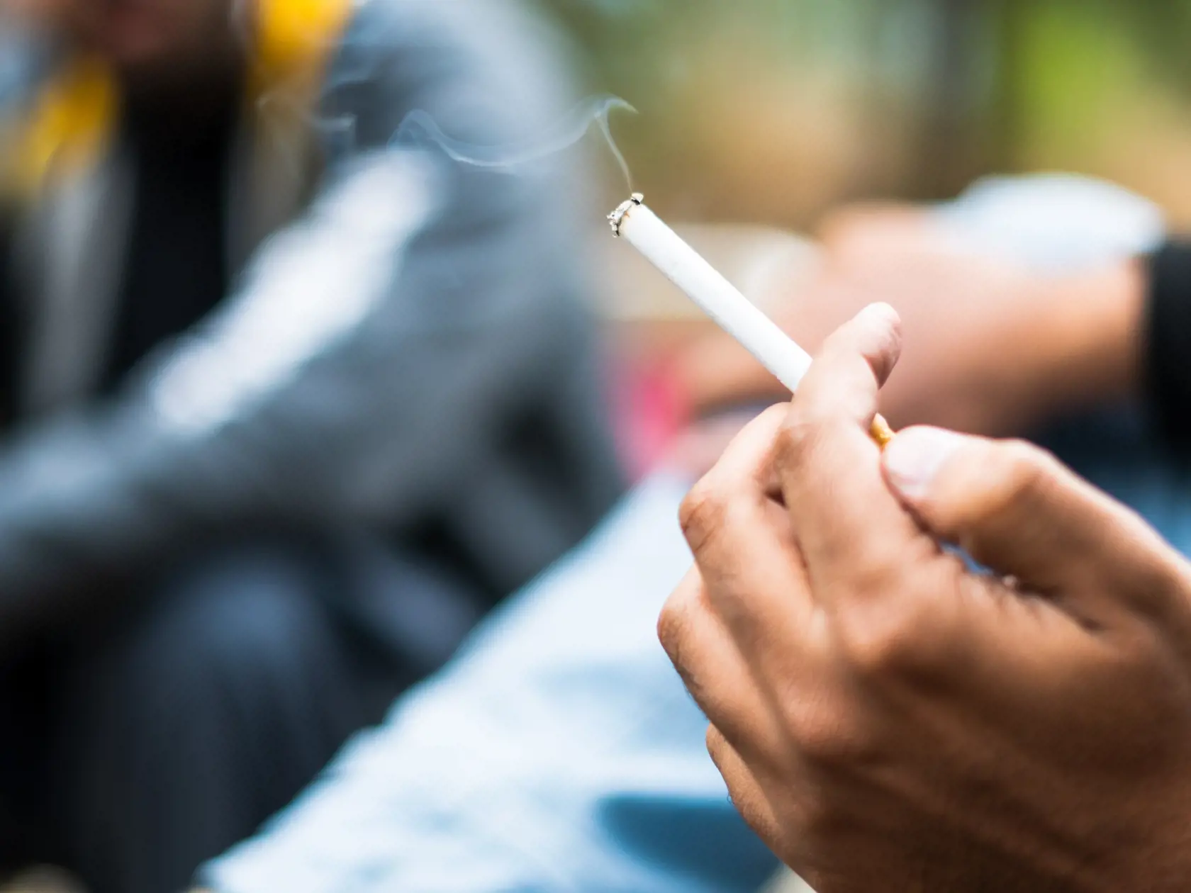 burning smoke cigarette in hand 