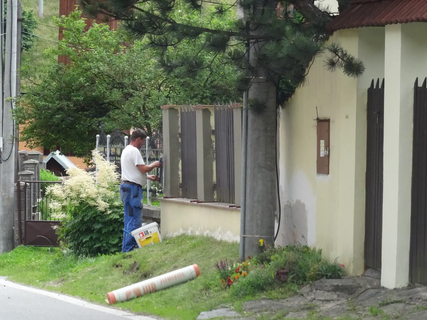 Mladý remeselník opravoval múrik i plot pred domom Paškovcov. (archív)