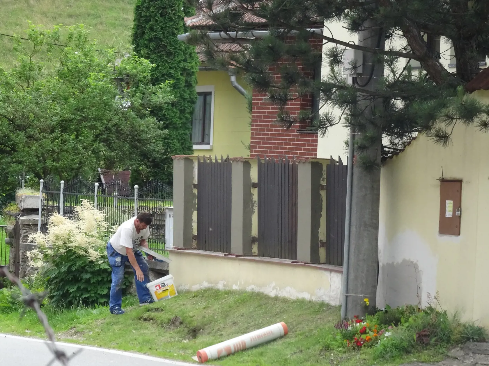 Mladý remeselník opravoval múrik i plot pred domom Paškovcov. (archív)