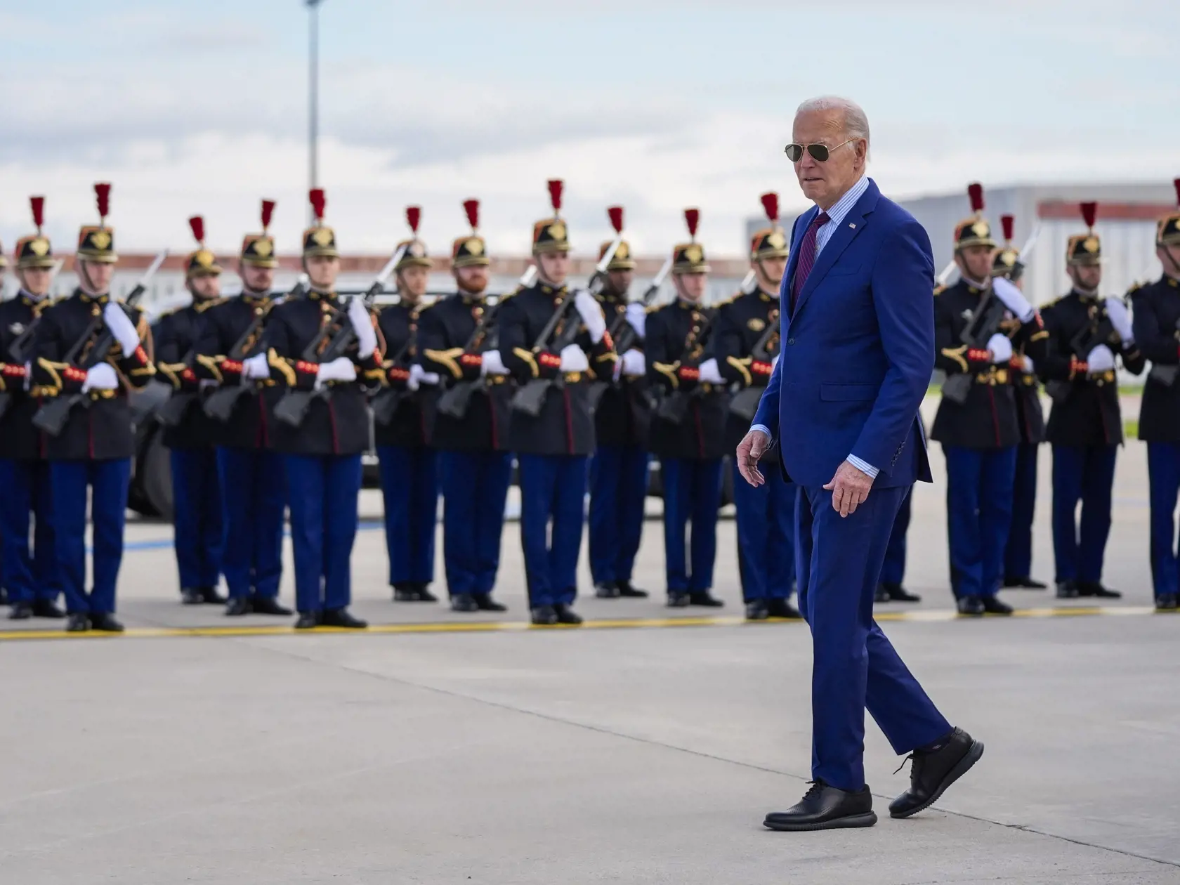 Na snímke americký prezident Joe Biden prechádza okolo čestnej stráže v stredu 5. júna 2024 na letisku Orly južne od Paríža. Prezident Joe Biden si tento týždeň pripomenie 80. výročie dňa D, invázie vylodenia spojencov v Normandii.