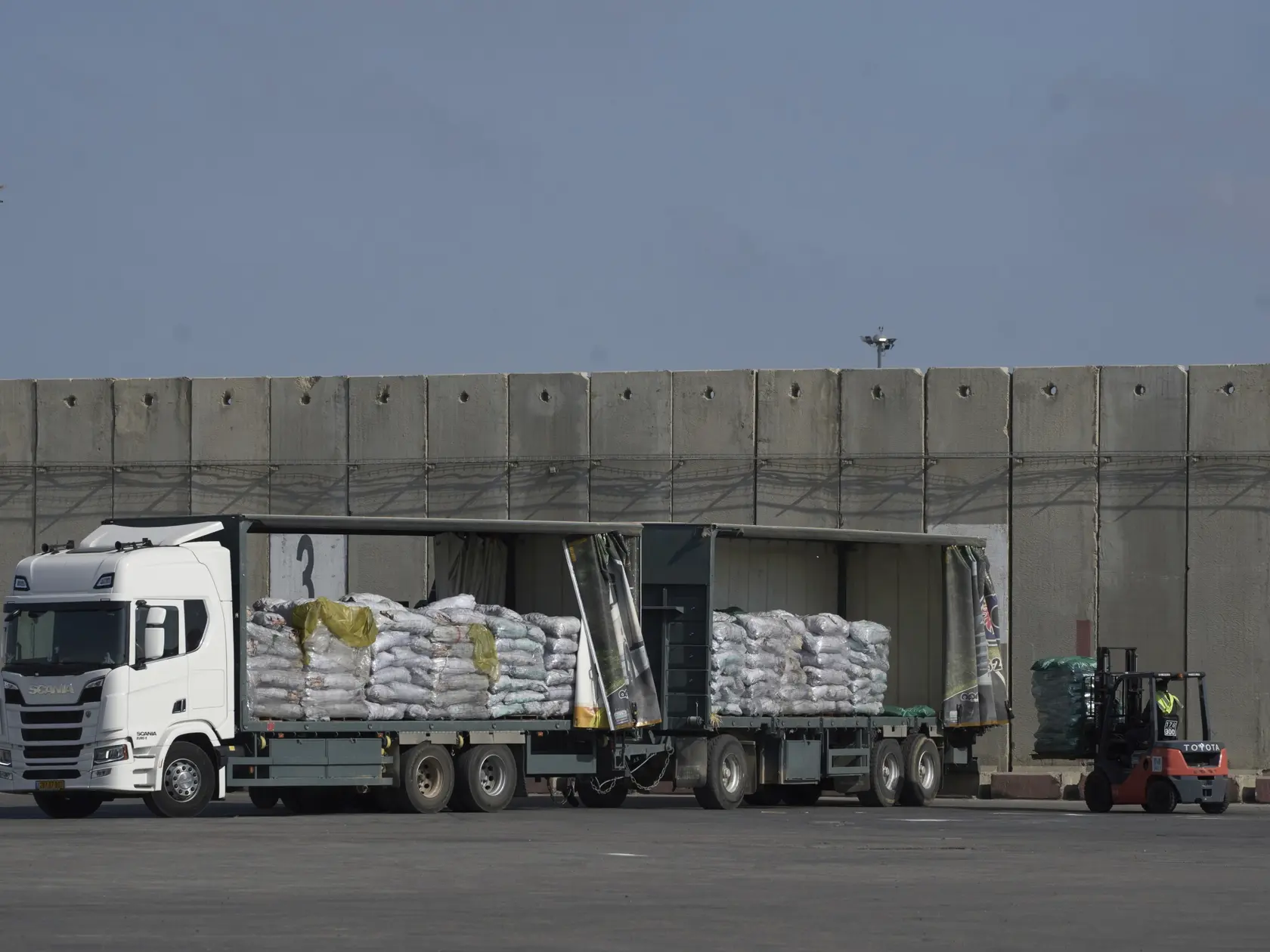 KK19 Gaza - Pracovník vykladá nákladné auto s humanitárnou pomocou pre Pásmo Gazy na hraničnom priechode Kerem Šalom, v južnom Izraeli vo štvrtok 22. mája 2025. Izraelský Úrad pre koordináciu vládnych aktivít na palestínskych územiach (COGAT), ktorý dohliada na civilné záležitosti na palestínskych územiach, informoval, že v stredu vstúpilo do Pásma Gazy 100 kamiónov s humanitárnou pomocou. FOTO TASR/AP
A worker unloads cargo from a truck carrying humanitarian aid for the Gaza Strip at the offload area of the Kerem Shalom border crossing between Israel and Gaza, southern Israel, Thursday, May 22, 2025. (AP Photo/Leo Correa)