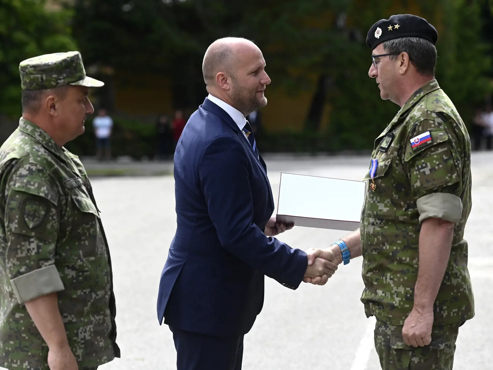 Na snímke uprostred minister obrany SR Jaroslav Naď (OĽaNO) sa lúči s odchádzajúcim veliteľom pozemných síl OS SR Jindřichom Jochom (vpravo), vľavo sa prizerá náčelník Generálneho štábu OS SR Daniel Zmeko sa počas slávnostného nástupu 7. júla 2020 v Trenčíne. Minister obrany SR Jaroslav Naď a náčelník Generálneho štábu OS SR Daniel Zmeko sa v priestoroch kasárni Slovenského národného povstania v Trenčíne zúčastnili na slávnostnom nástupe pri príležitosti rozlúčky s veliteľom pozemných síl OS SR 