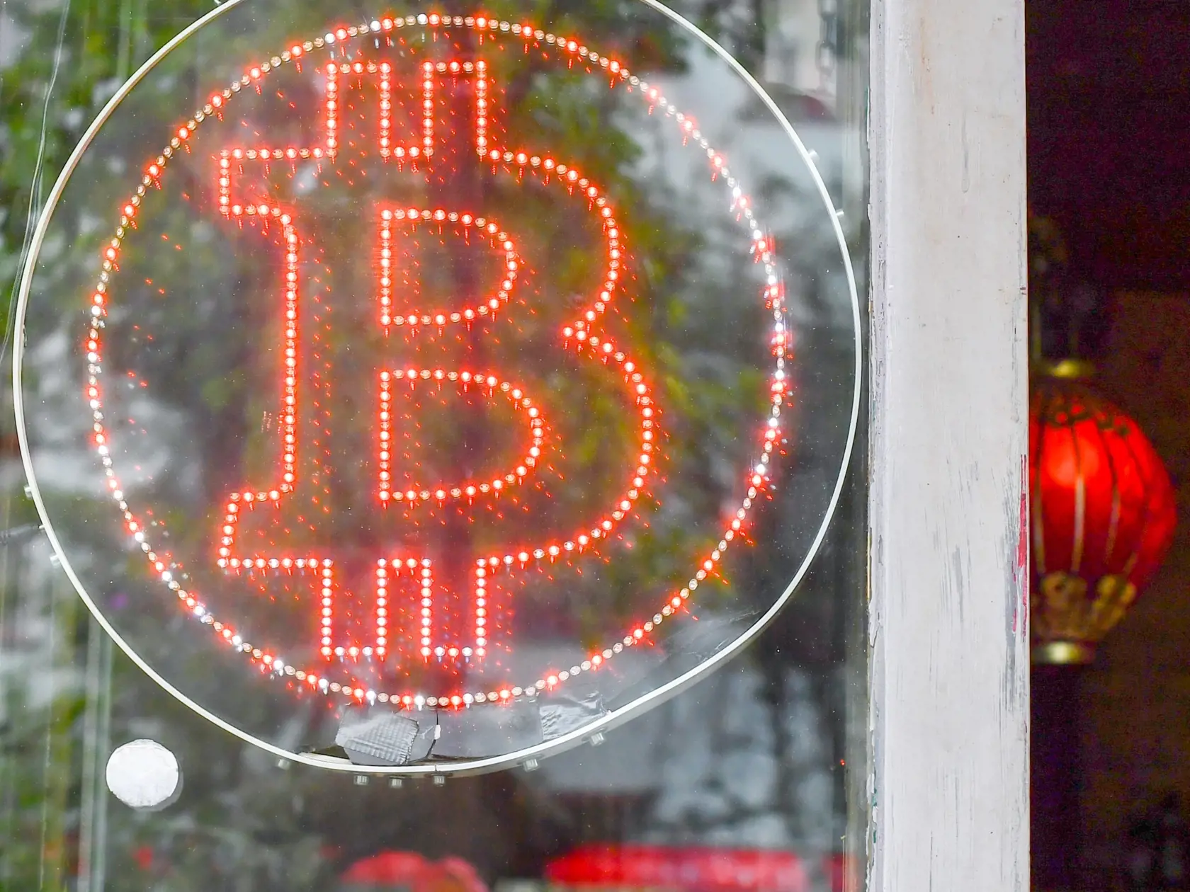 Na archívnej snímke z 19. júna 2018 logo bitcoinu na okne krčmy v Berlíne. Bitcoin pokračuje v raste a prelamovaní rekordov aj v novom roku. Jeho cena sa vo štvrtok 7. januára 2021 prvýkrát dostala nad 39.000 USD (31.769,30 eura). To zvýšilo celkovú hodnotu trhu s kryptomenami nad 1 bilión USD.