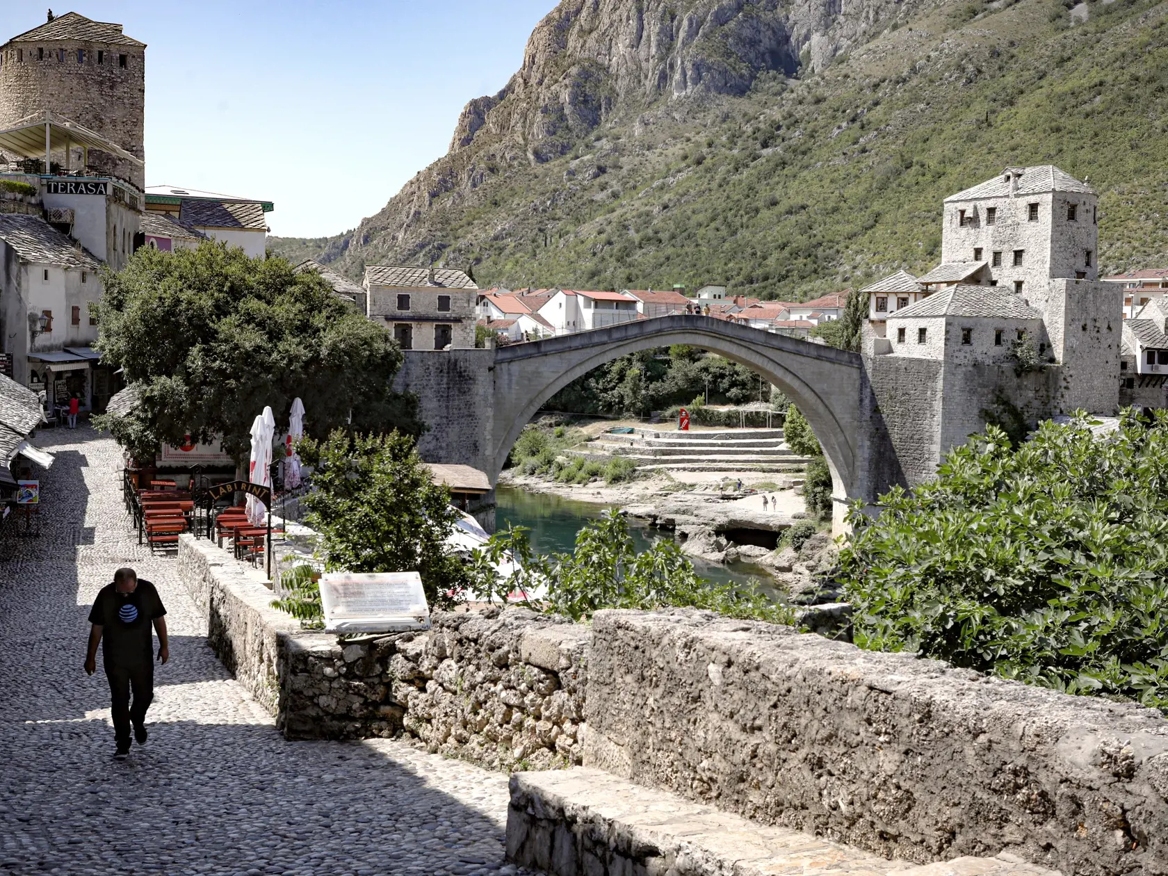 WA 26 Mostar - Muž kráča prázdnou ulicou pri Starom moste v Mostare, ktorý je jednou z najznámejších turistických pamiatok v krajine v utorok 2. júla 2020. Stovky ľudí pracujúcich v cestovnom ruchu protestovali proti vládnemu nariadeniu, ktoré zakazuje vstup občanom EÚ do krajiny. Ako dodali, tisíce z nich prídu o prácu, ak nebudú otvorené hranice pre občanov EÚ. Nepodarí sa im totiž prežiť z príjmov od turistov zo Srbska, Chorvátska alebo Čiernej Hory, ktorí majú do Bosny vstup povolený.