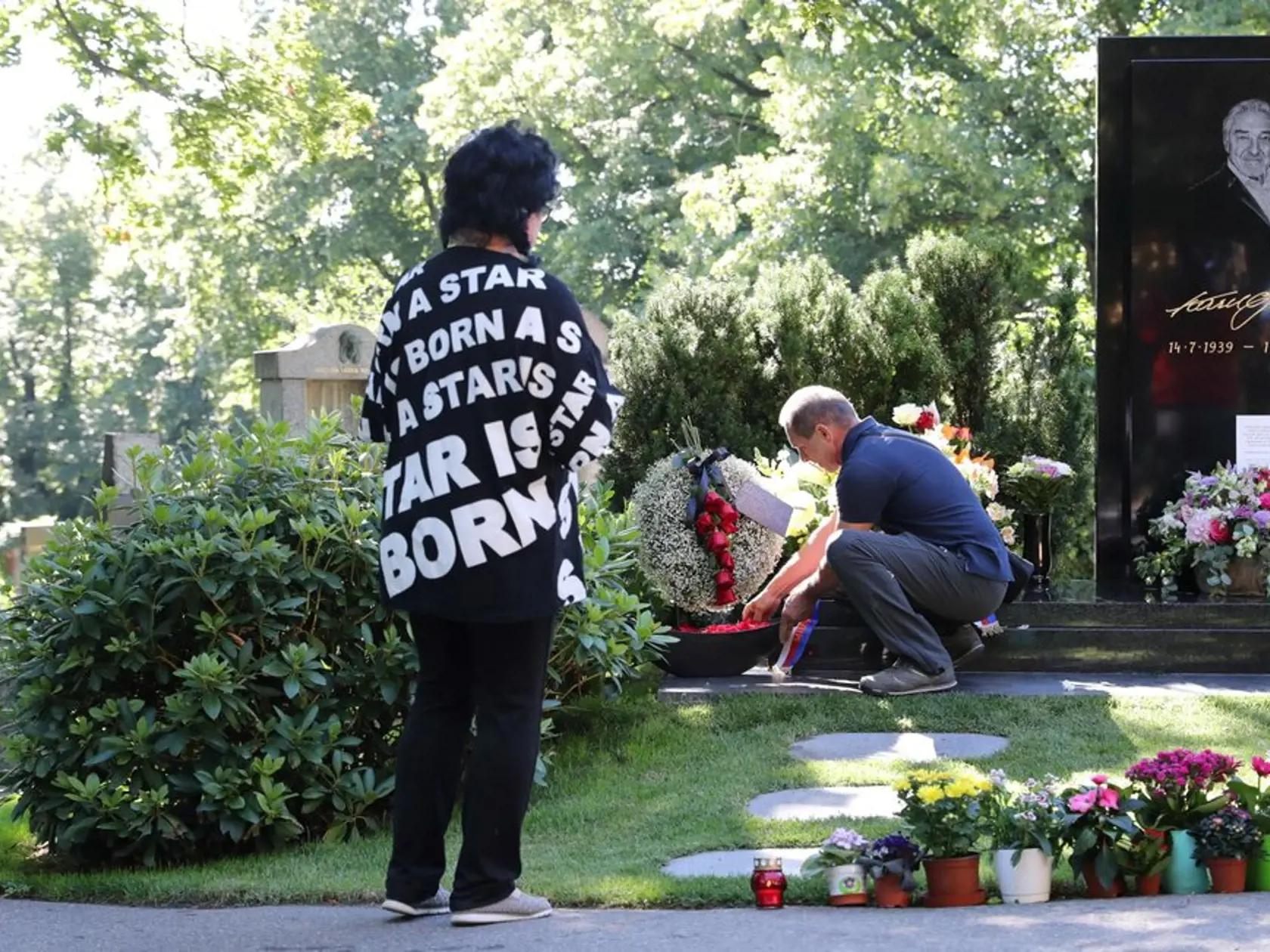 Manžel pomáha Ľubici - ukladanie venca k hrobu Karla Gotta.