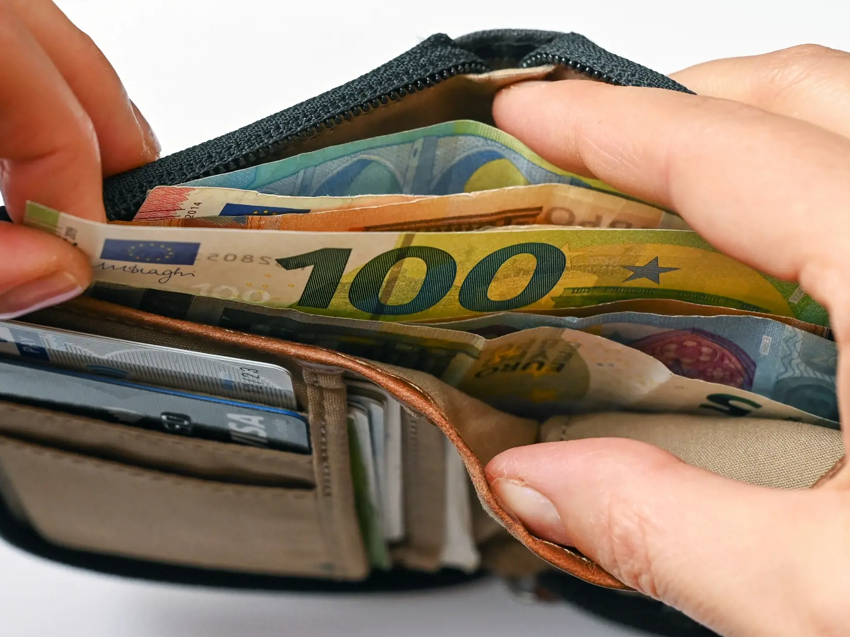 WA 41 archív Sieversdorf - Na archívnej snímke zo 17. marca 2021 muž vyťahuje z peňaženky bankovku v hodnote 100 eur v nemeckom Sieversdorfe. Miera inflácie sa v eurozóne zrýchlila v septembri 2022 na nový rekord, tempo rastu však bolo miernejšie, než uvádzal rýchly odhad a inflácia tak zatiaľ dvojcifernú úroveň nedosiahla. Spotrebiteľské ceny v eurozóne vzrástli v septembri medziročne o 9,9 % po 9,1-percentnom raste v auguste. Na porovnanie, v septembri minulého roka dosiahla medziročná miera i