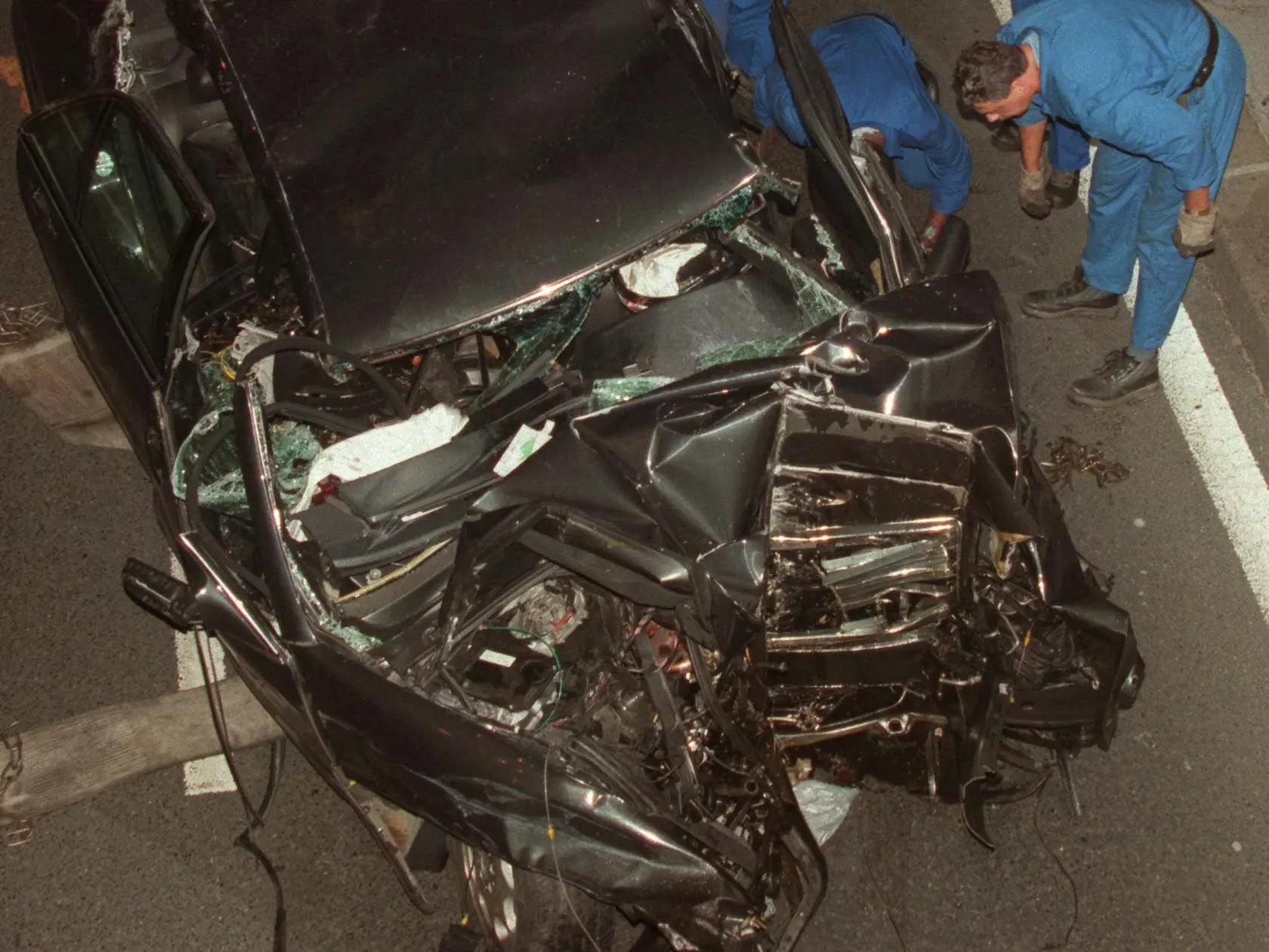 Na archívnej snímke z 31. augusta 1997 policajti odťahujú vrak automobilu značky Mercedes, v ktorom zahynula princezná Diana ,  jej priateľ Dodi Al Fayed a vodič auta Henri Paul v centre Paríža. K havárii došlo krátko po polnoci v nedeľu 31. augusta v parížskom tuneli pod námestím de l`Alma, keď Dianine auto prenasledovali fotoreportéri.