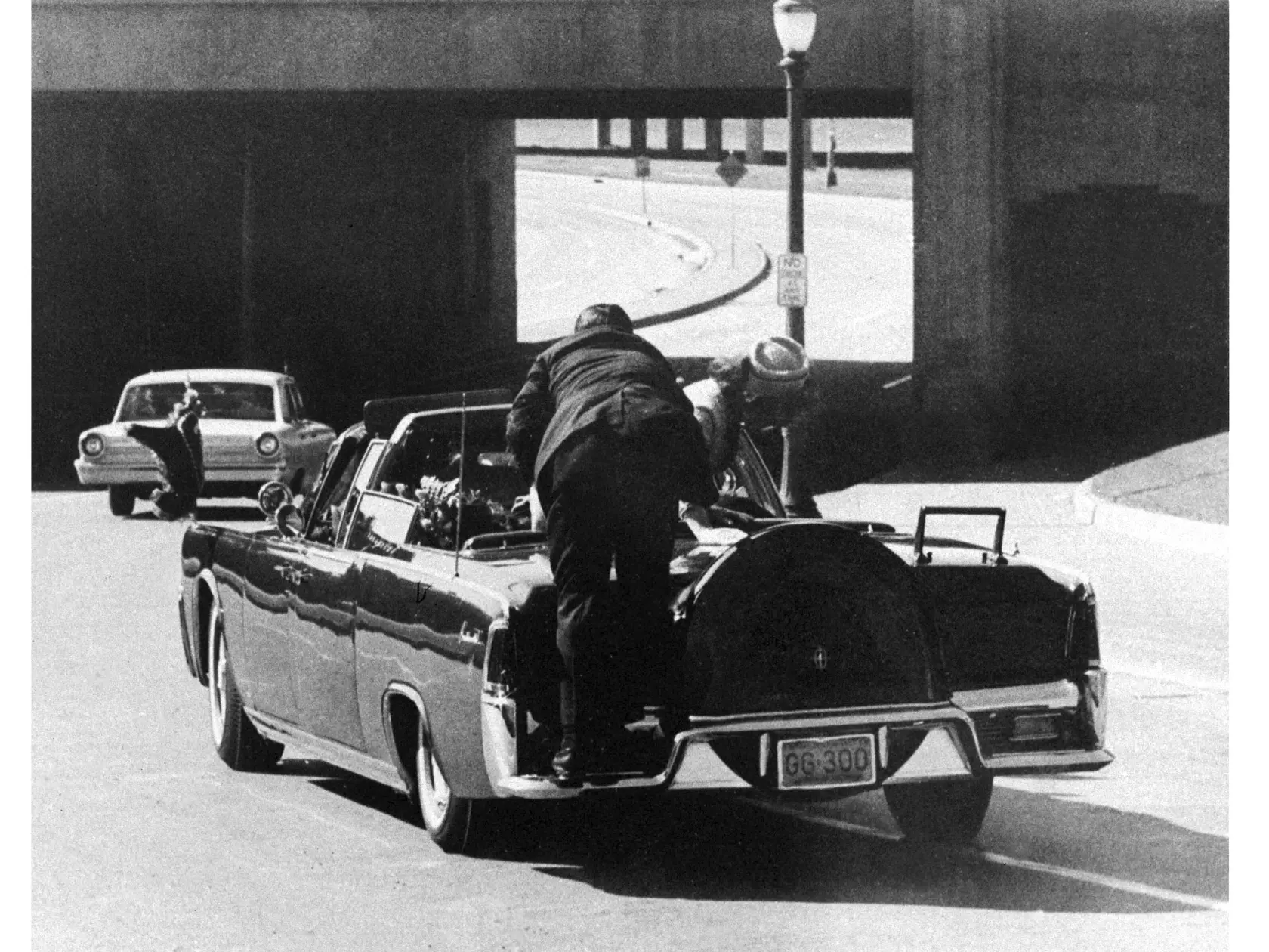 Na archívnej snímke z 22. novembra 1963 americký prezident John F. Kennedy padá po atentáte na zadné sedadlo limuzíny v Dallase v americkom štáteTexas. Clint Hill, agent americkej tajnej služby, ktorý sa ako prvý vrhol na limuzínu prezidenta Johna F. Kennedyho.