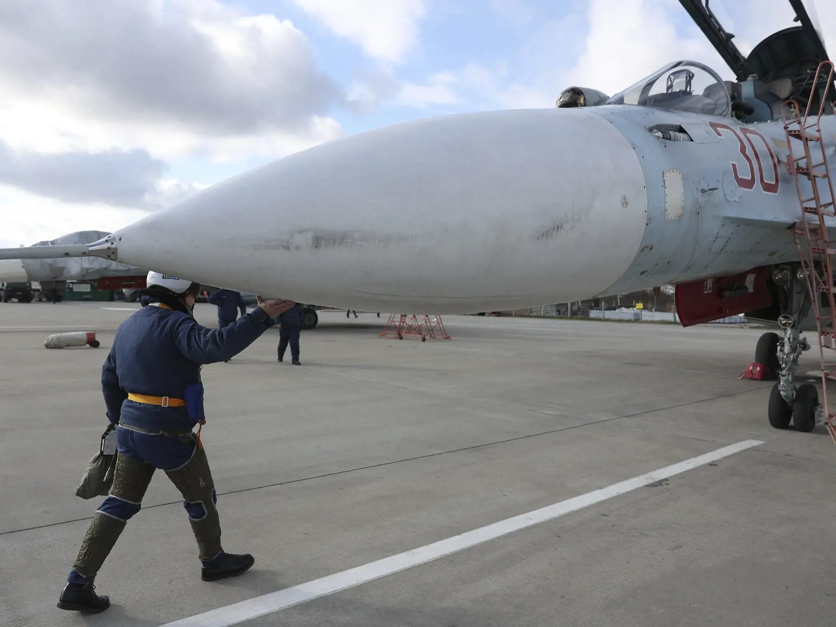 WA 6 - Pilot kráča k ruskému stíhaciemu lietadlu SU-30 počas cvičenia v Krasnodarskej oblasti v stredu 19. januára 2022. Ruské vojenské námorníctvo uskutoční v januári a februári sériu námorných cvičení, ktoré sa odohrajú v Atlantickom oceáne, Tichomorí, Arktíde a v Stredozemnom mori. Agentúra AFP poznamenala, že avizované vojenské cvičenia sa odohrajú v čase zvýšeného napätia vo vzťahoch medzi Ruskom a Západom, ktorý Moskvu podozrieva z hromadenia jednotiek pri hraniciach s Ukrajinou a prípravy