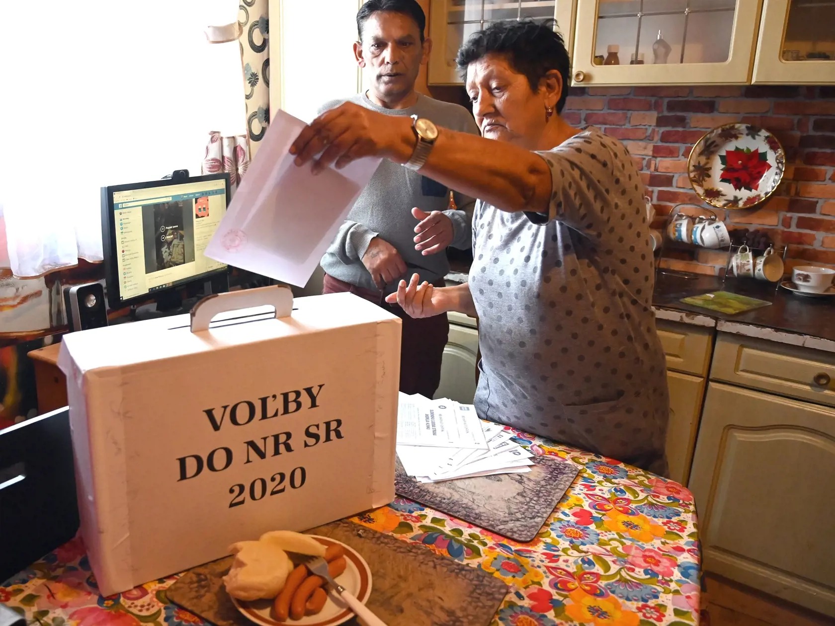 Na snímke volička vhadzuje hlasovací lístok v obálke do prenosnej volebnej schránky vo voľbách do Národnej rady Slovenskej republiky v rómskej osade v Trebišove 29. februára 2020. FOTO TASR - Roman Hanc

