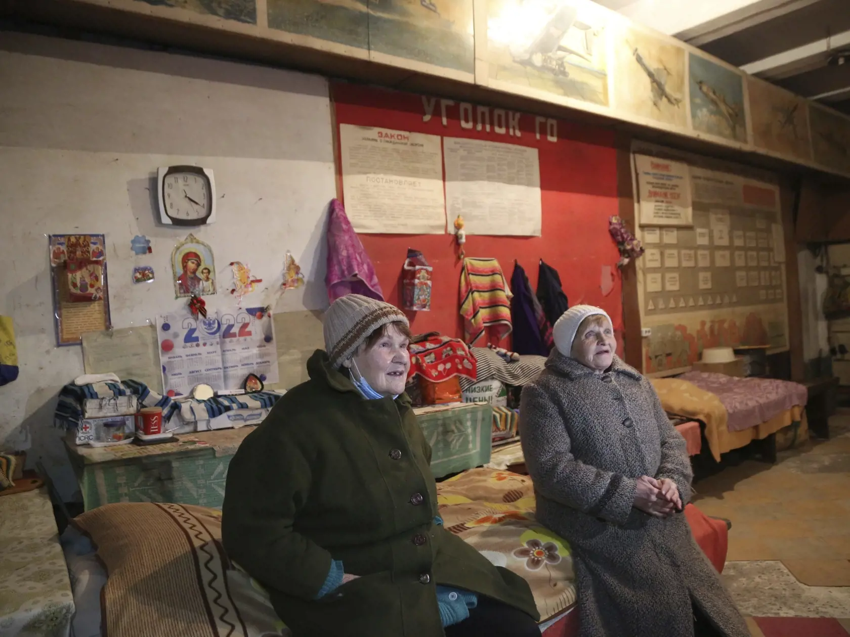 Ljudmila (vpravo) a Galina sedia v kabátoch a pozerajú televízor v starom a chladnom protileteckom kryte v dedine Trudivske na predmestí Donecka na východe Ukrajiny v utorok 1. februára 2022.